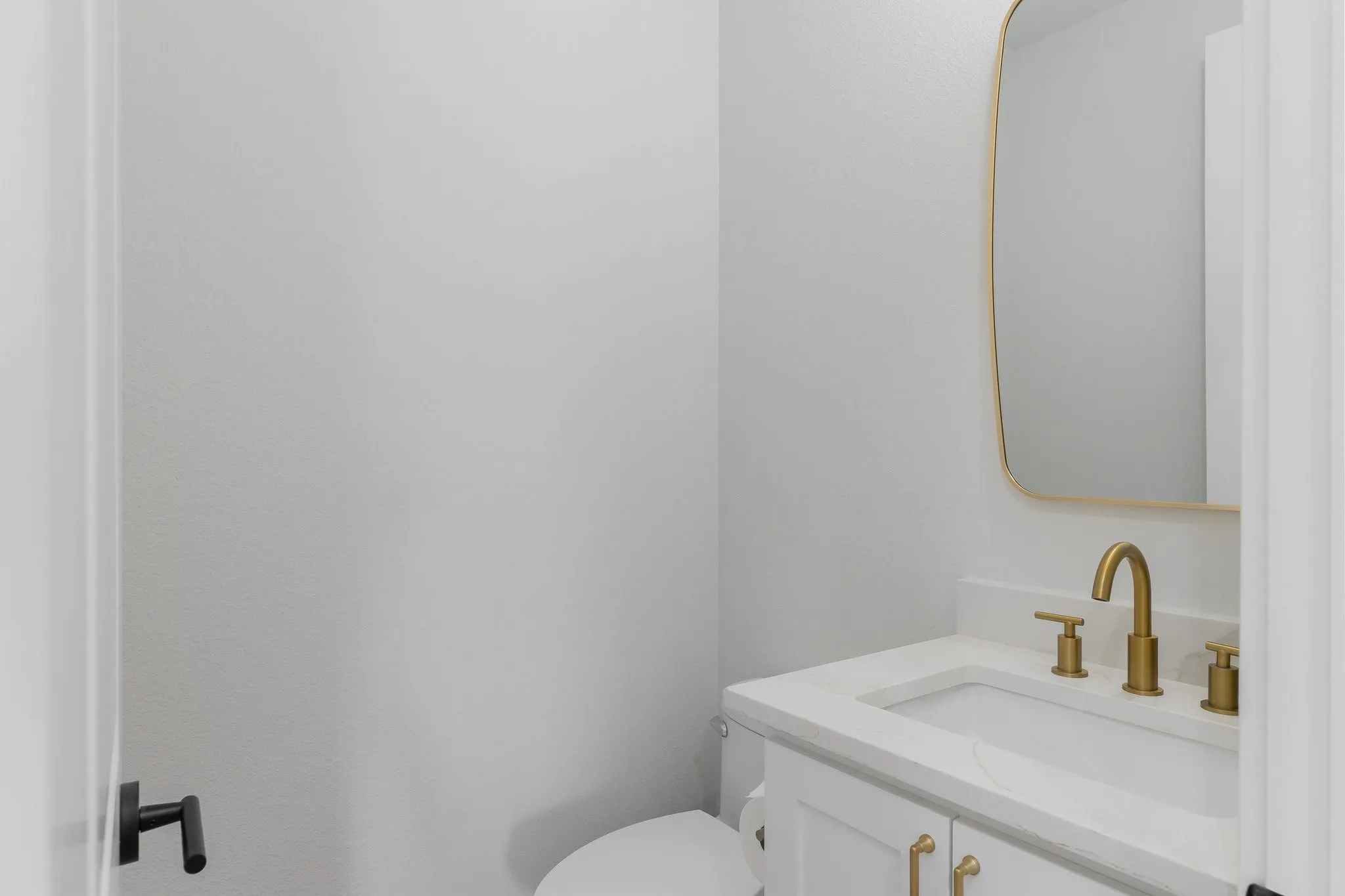 Half bathroom featuring vanity and toilet