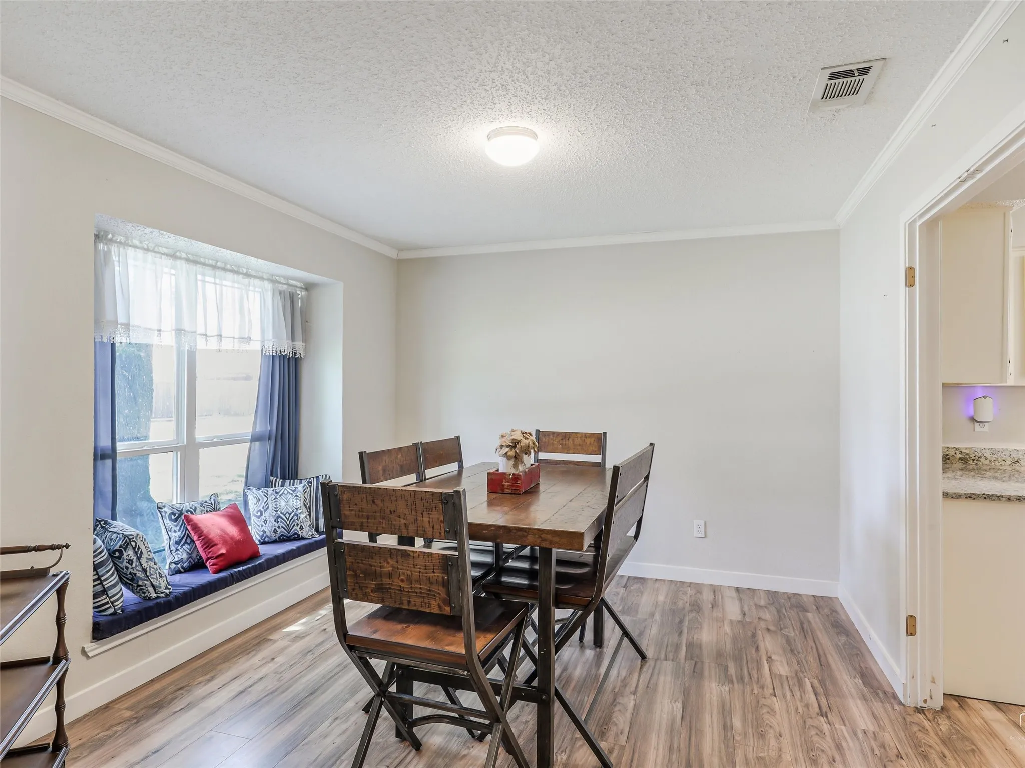 Bathed in natural light, this dining space feels warm and welcoming. The window seat adds charm and versatility—perfect for slow mornings, casual meals, or simply a spot to sit and take in the day.