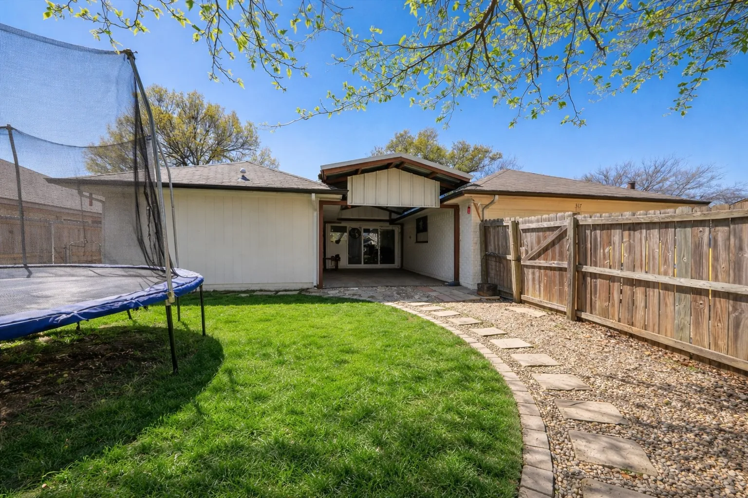 A seamless extension of the home, the covered patio creates a comfortable outdoor living area—ideal for morning coffee, evening conversations, or weekend get-togethers. The defined pathway and green space bring both function and charm to the backyard setting.