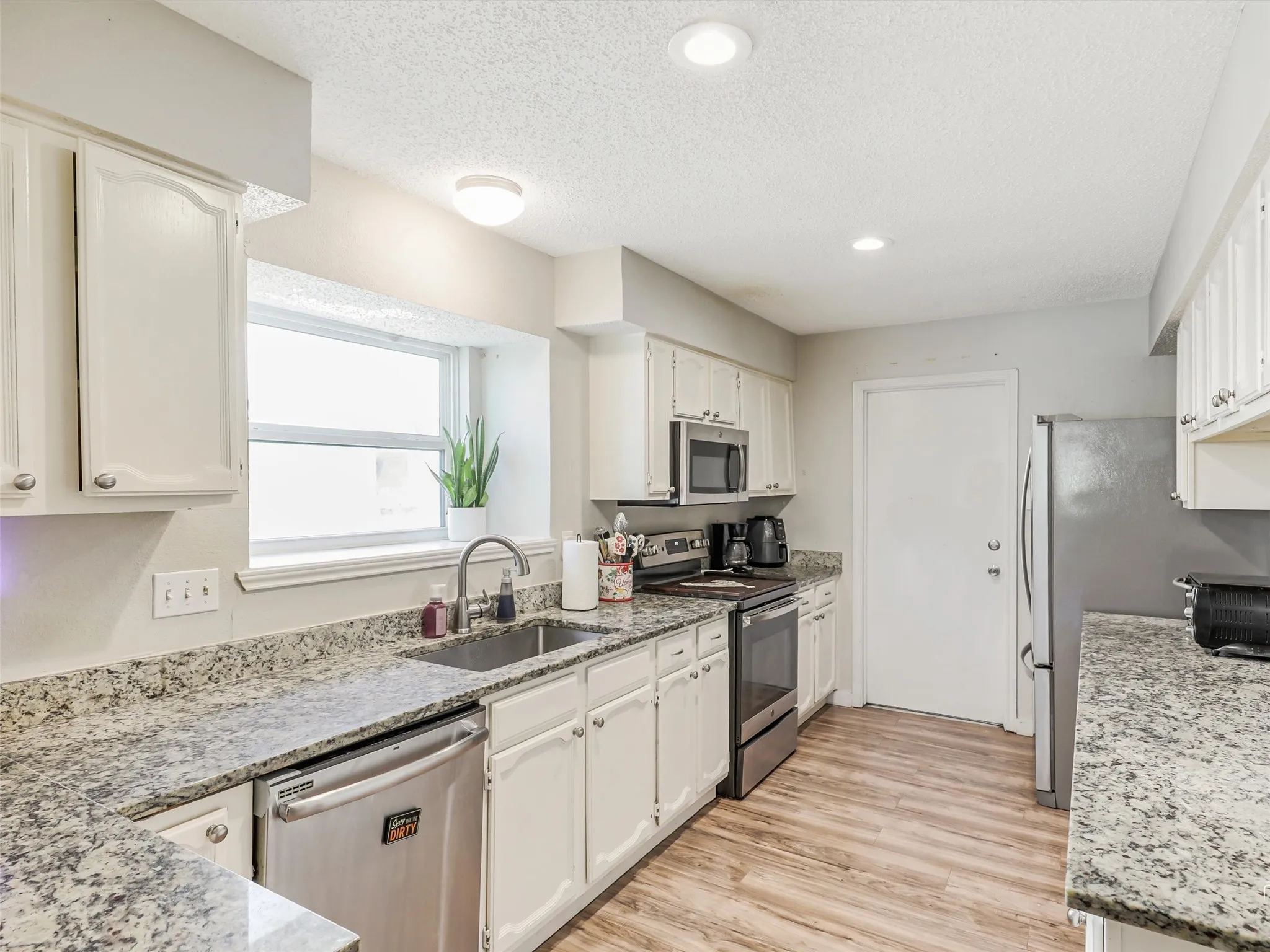 Bright, clean, and functional—the kitchen offers plenty of room to cook, prep, and gather. Granite countertops and stainless appliances bring a polished feel, while the layout keeps everything within reach.