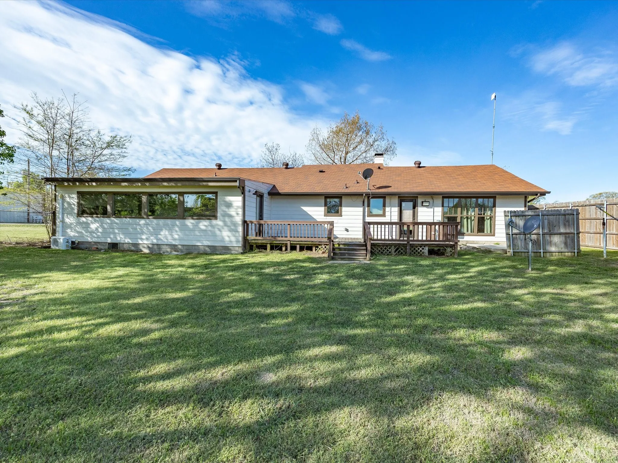 Expansive rear yard featuring a partial privacy fence
