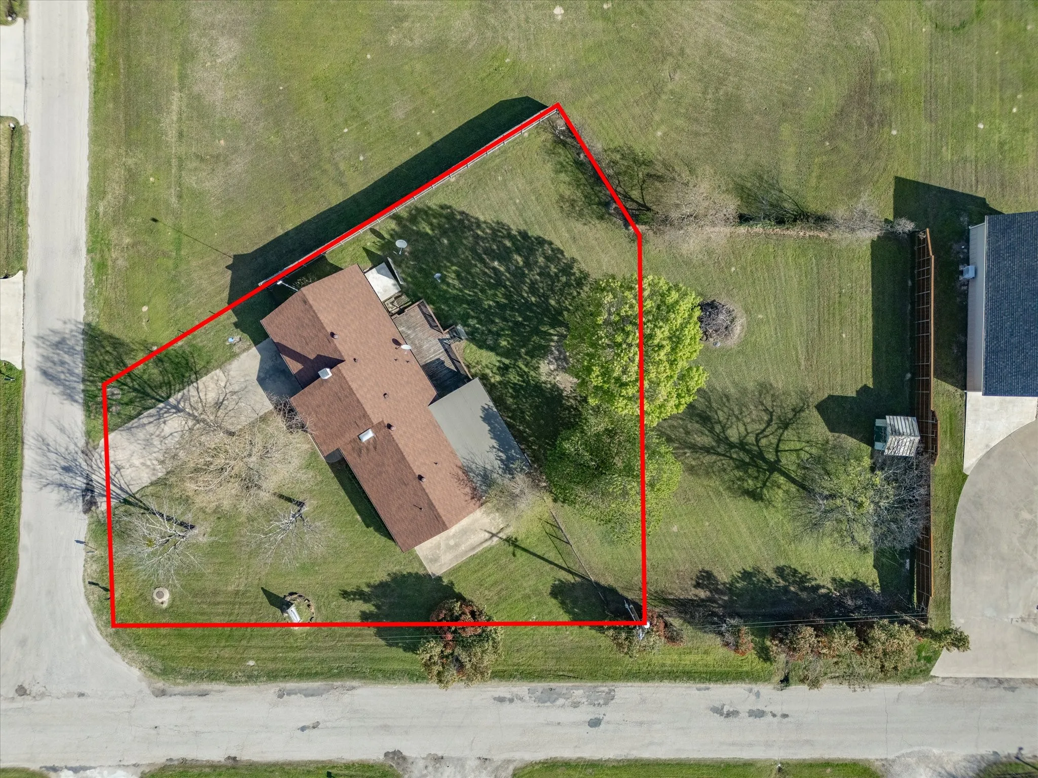 Expansive property featuring a paved driveway, established trees, and a direct visual to a pond and a large body of water