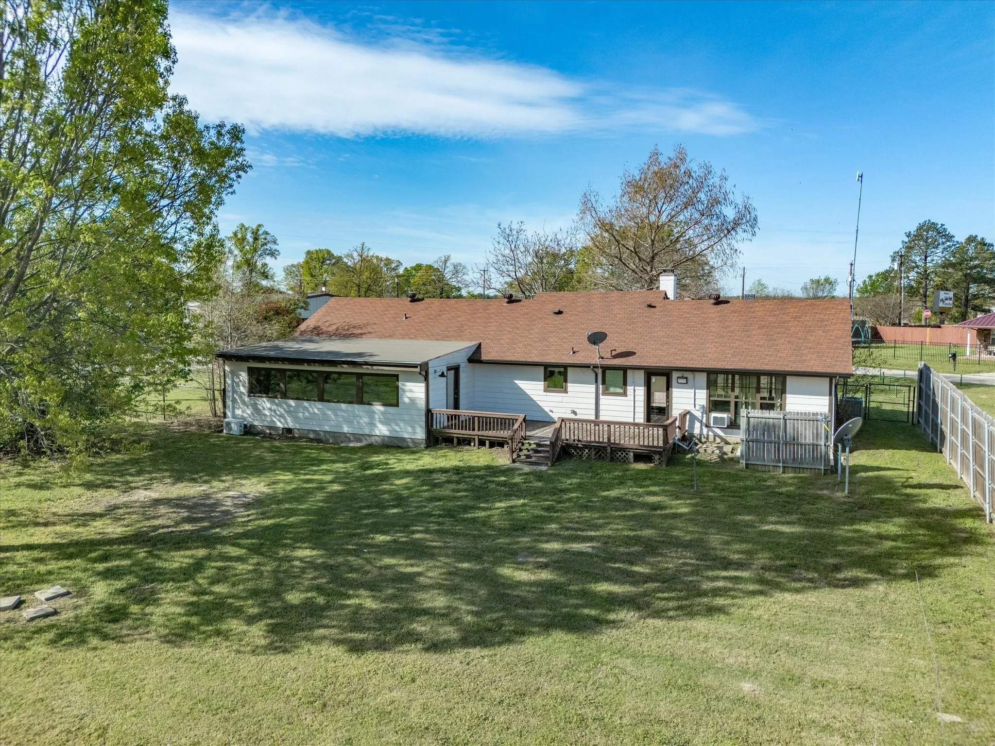 Aerial perspective showcasing a single-story residence with a paved driveway and mature landscaping