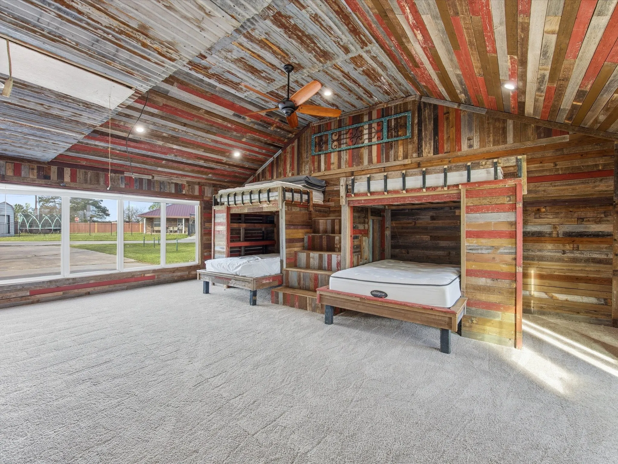Loft-style room featuring custom bunk beds, textured wood-paneling walls and ceiling, recessed lighting, and a ceiling fan