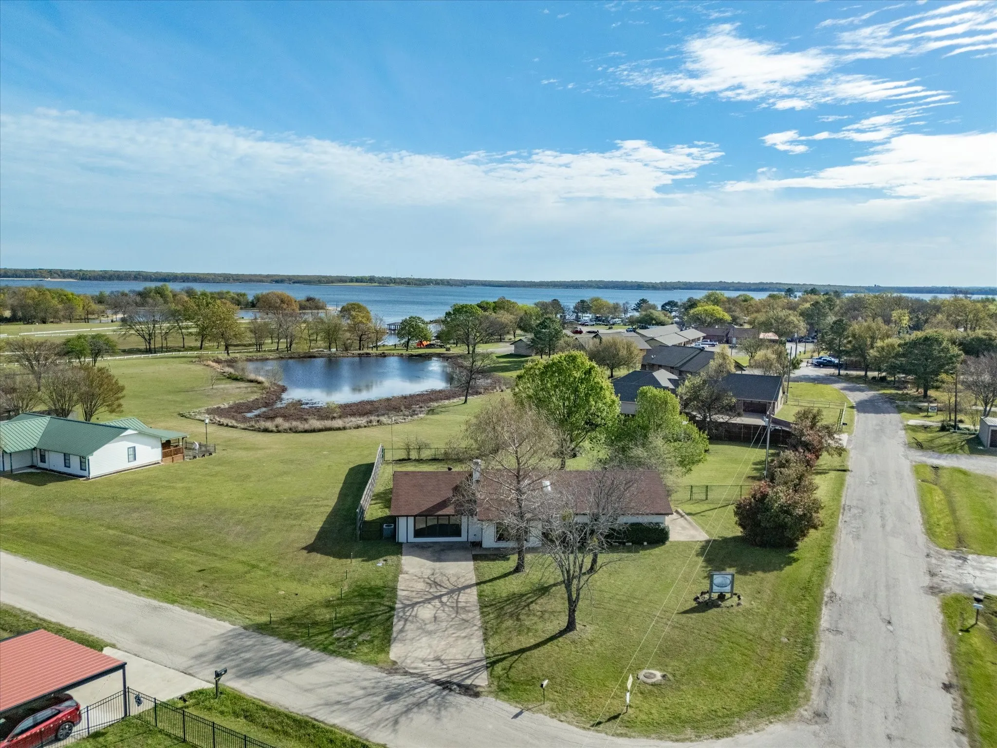 Expansive lakefront property featuring a private pond, mature trees, and direct water access