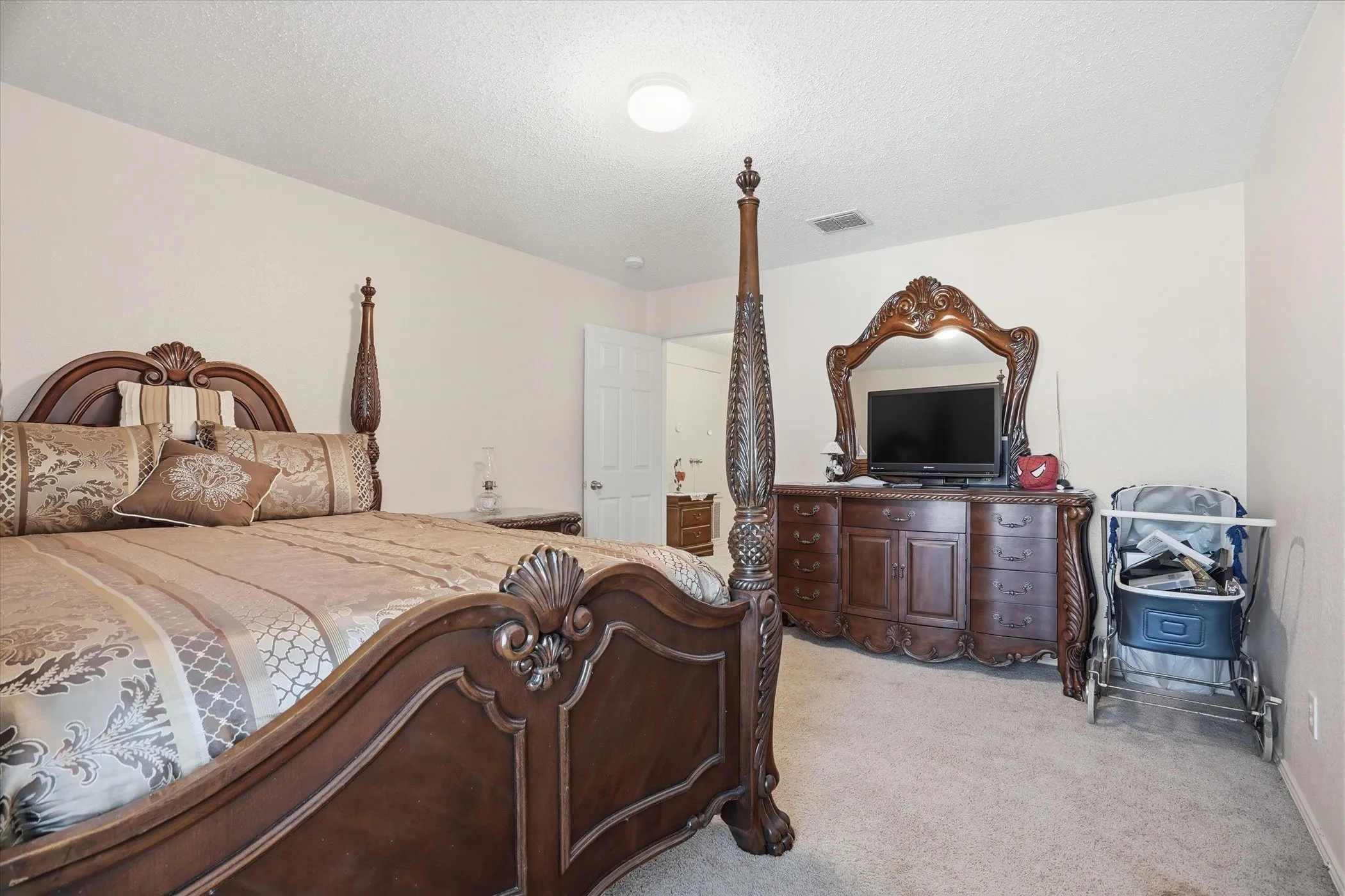 Bedroom featuring light carpet and a textured ceiling