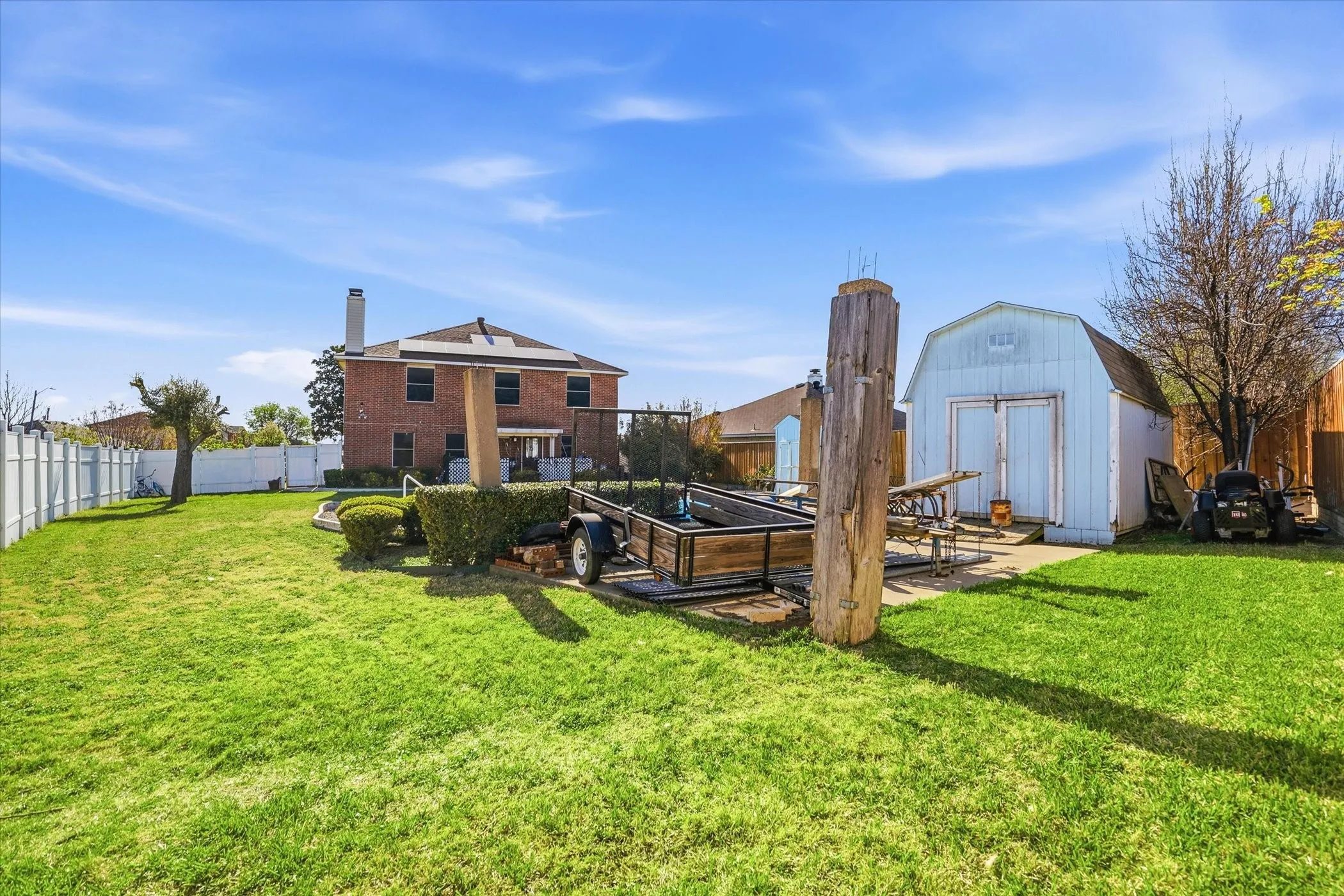 Fenced backyard featuring a storage shed, a vegetable garden, and a patio area