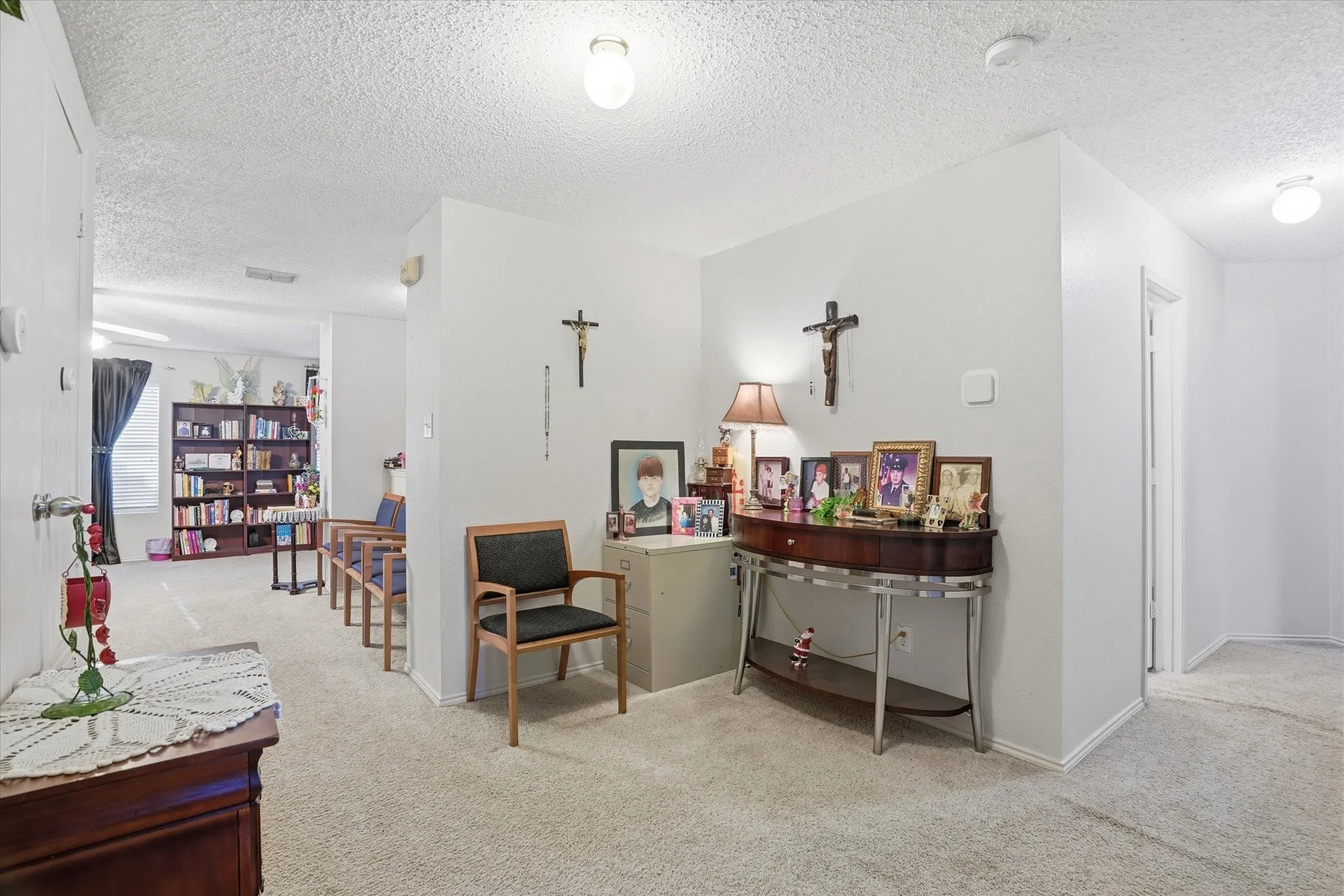 Living area with light colored carpet and a textured ceiling