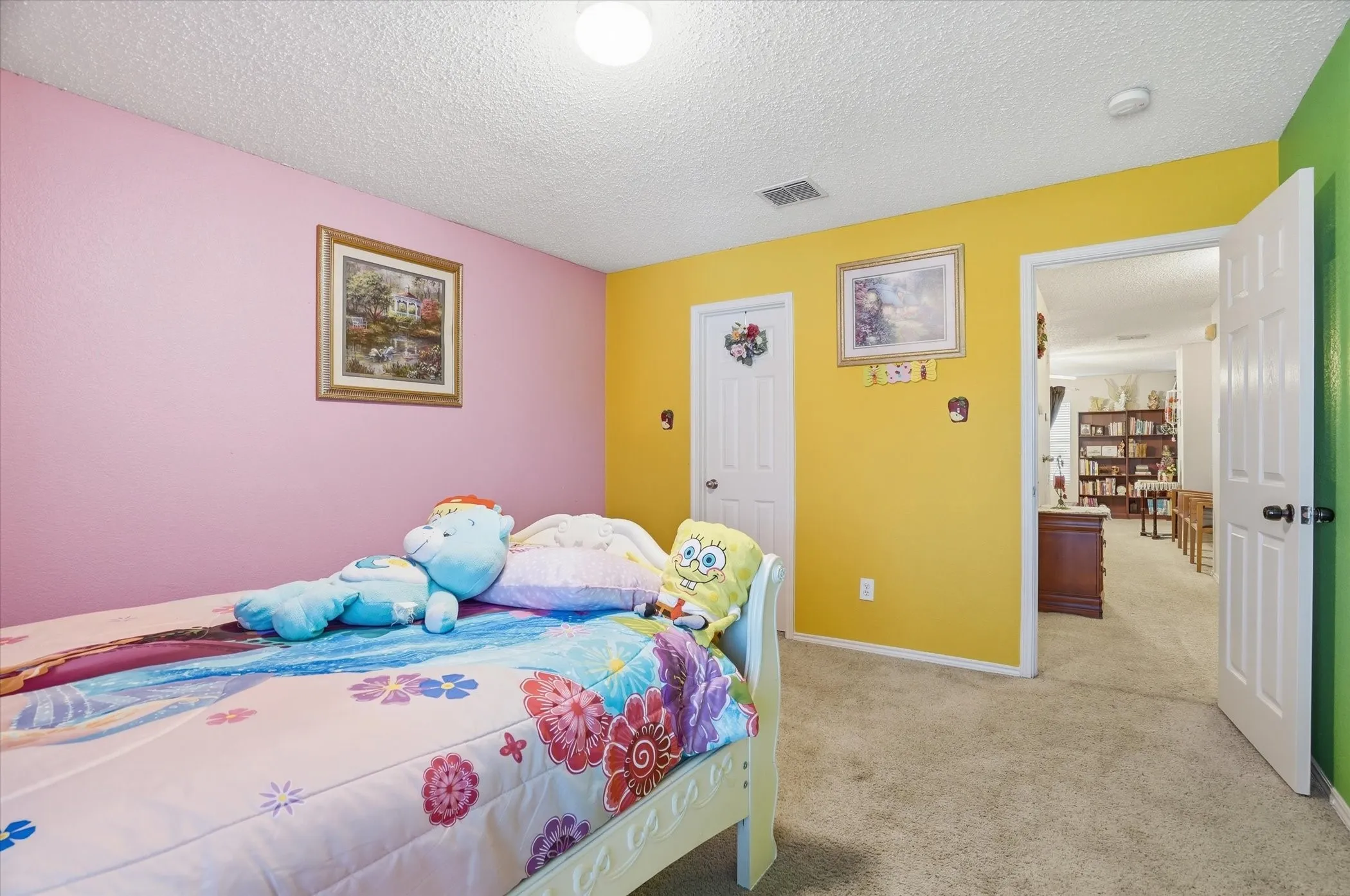 Bedroom with light colored carpet and a textured ceiling