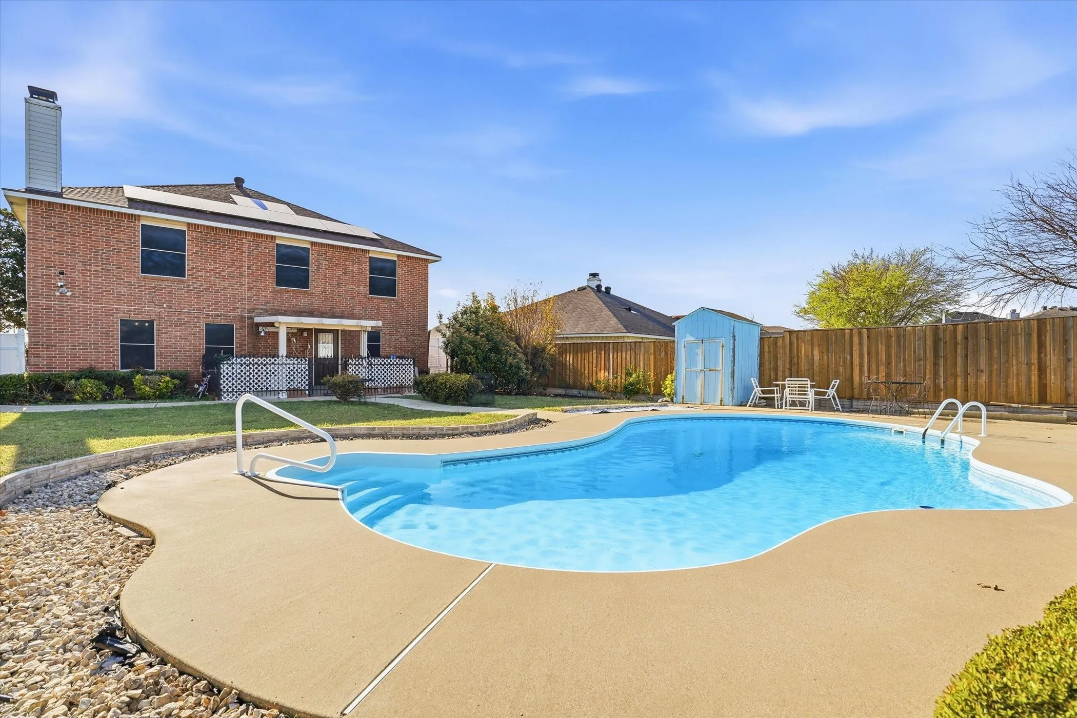 View of swimming pool featuring a shed and a fenced backyard