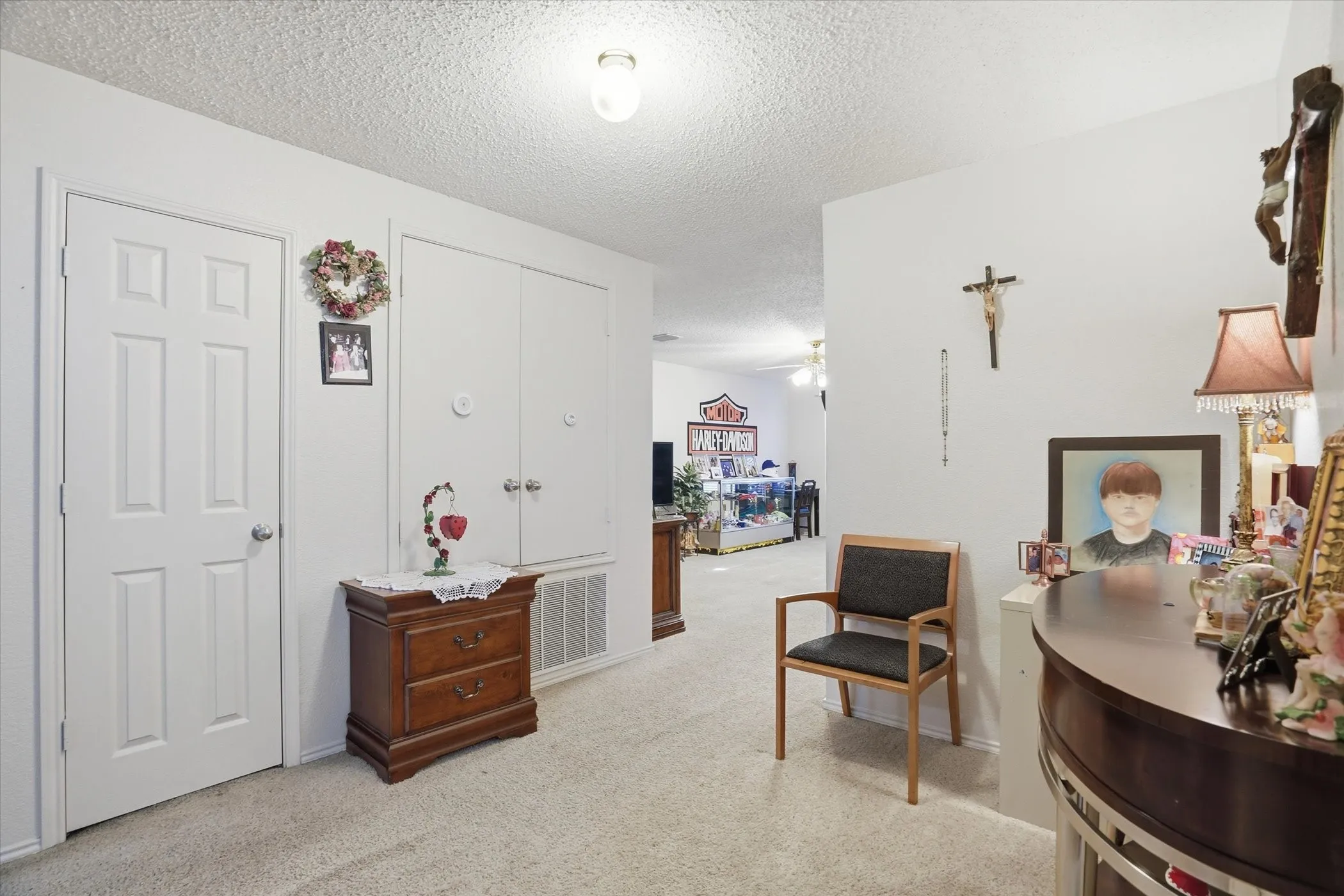 Sitting room with a textured ceiling, light carpet, and a ceiling fan