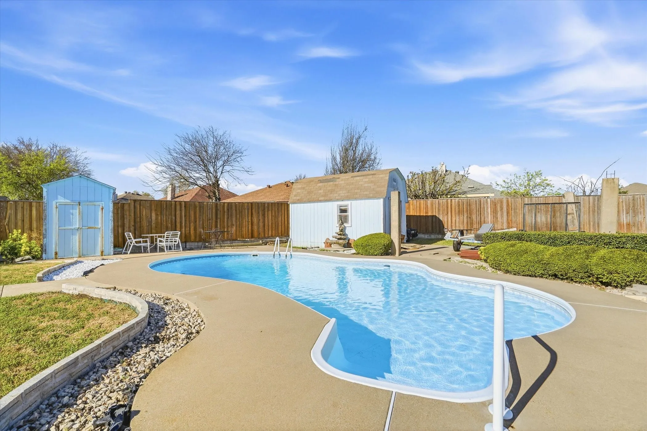 View of swimming pool featuring a storage shed, a fenced backyard, and patio surround