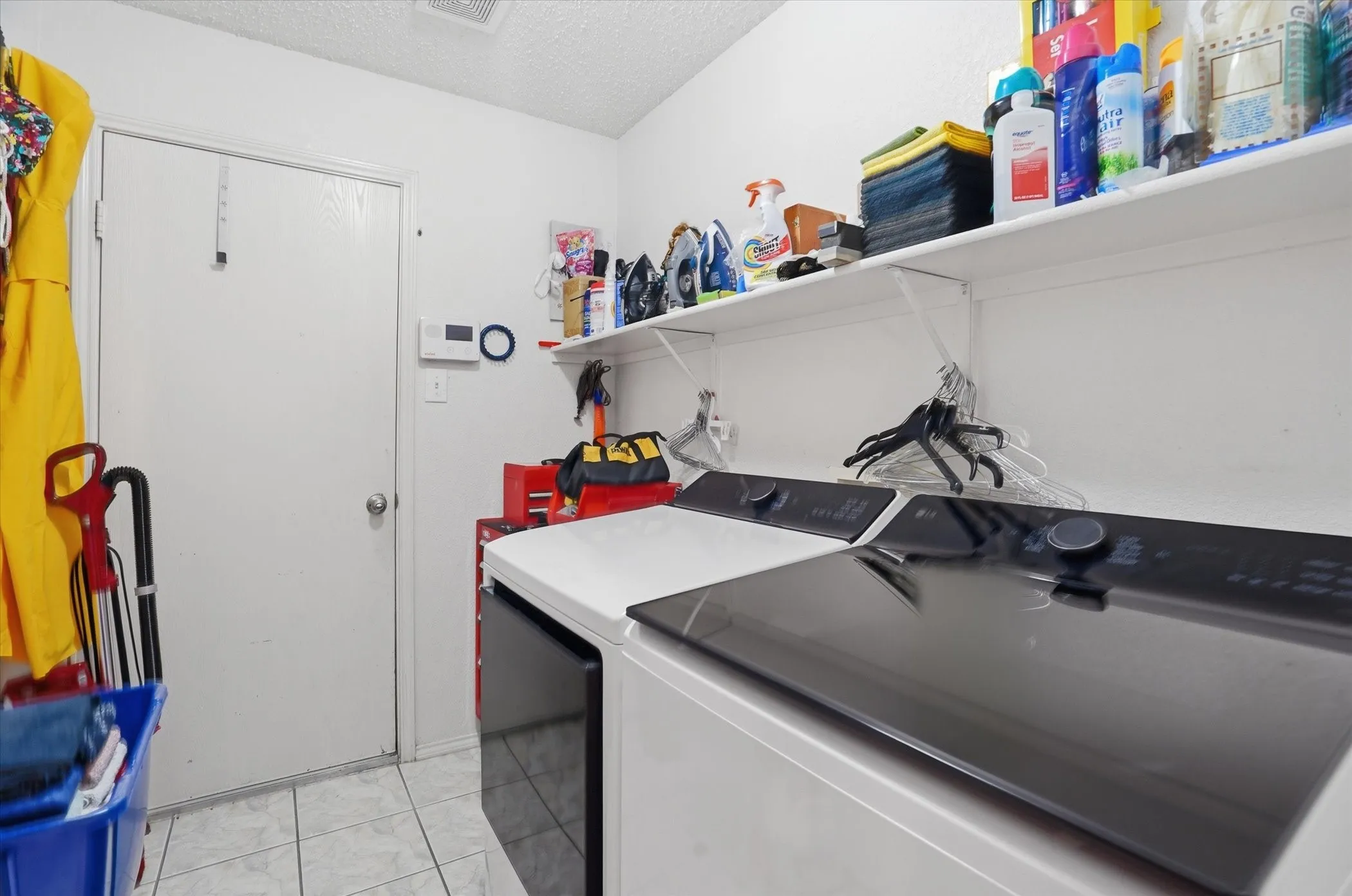 Laundry room featuring a textured ceiling and washing machine and clothes dryer