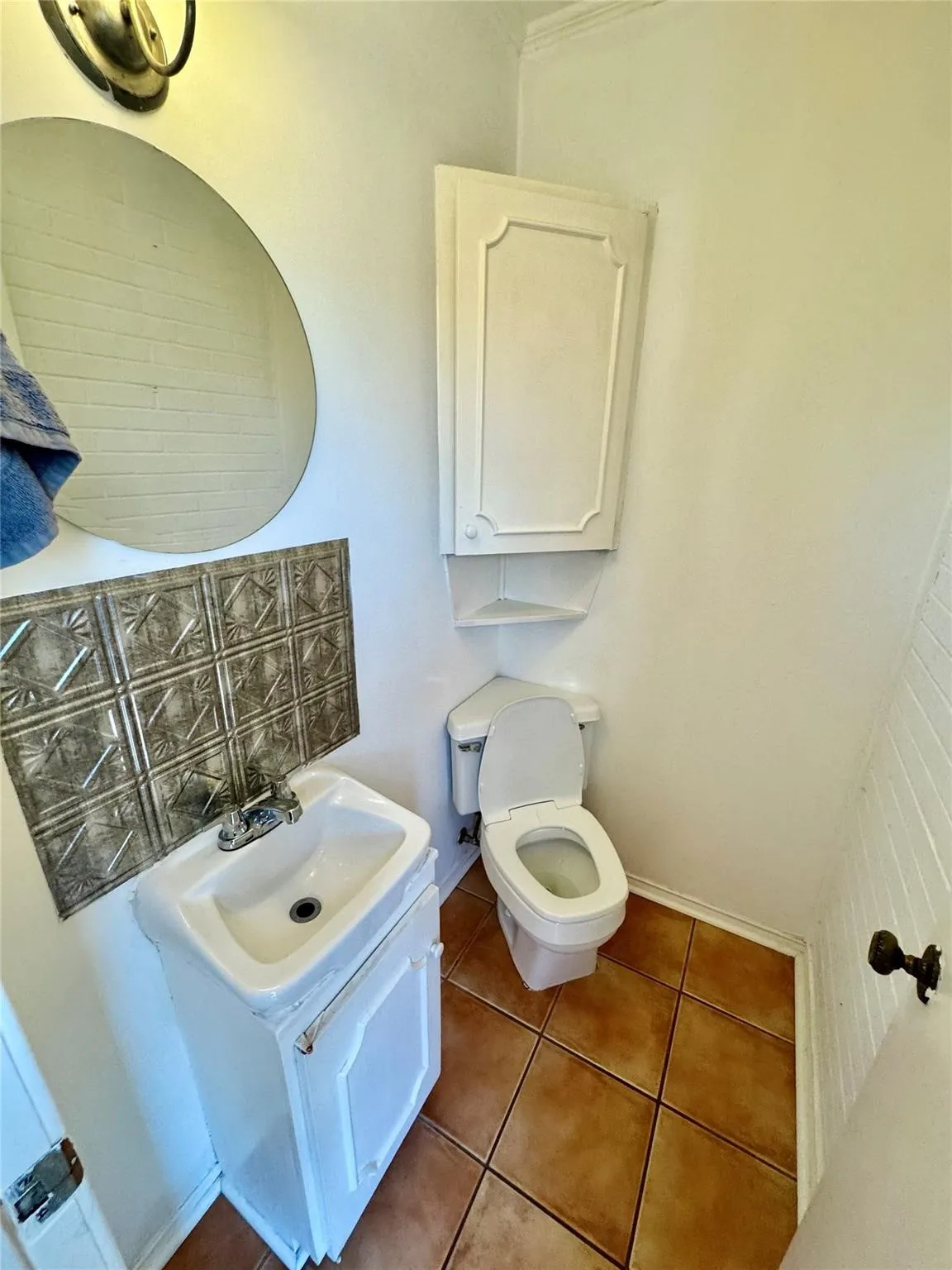 Bathroom with dark tile patterned floors and vanity