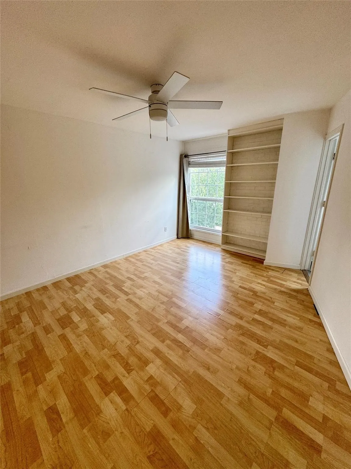 Unfurnished bedroom featuring a ceiling fan, light wood-style floors, and a textured ceiling
