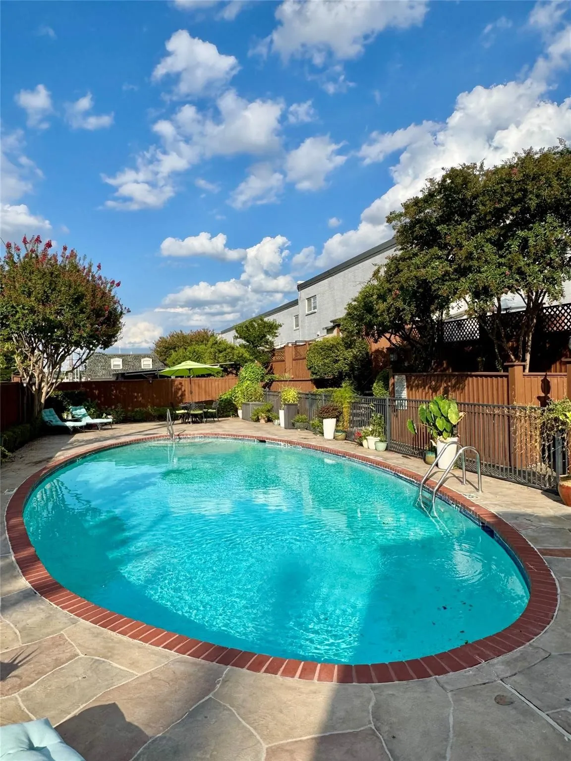 View of pool featuring a fenced backyard and patio surround