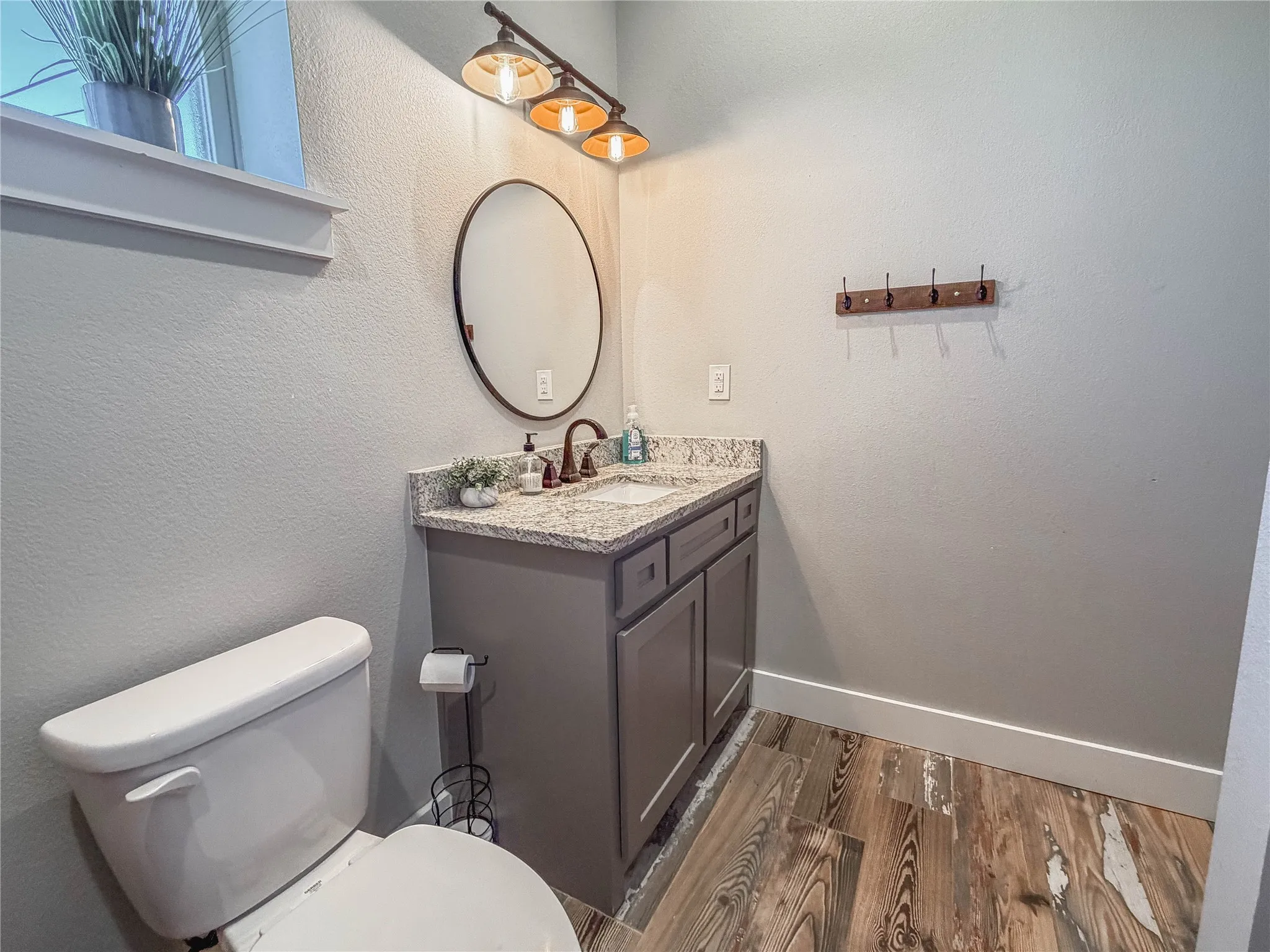 Half bath with vanity and dark wood-type flooring