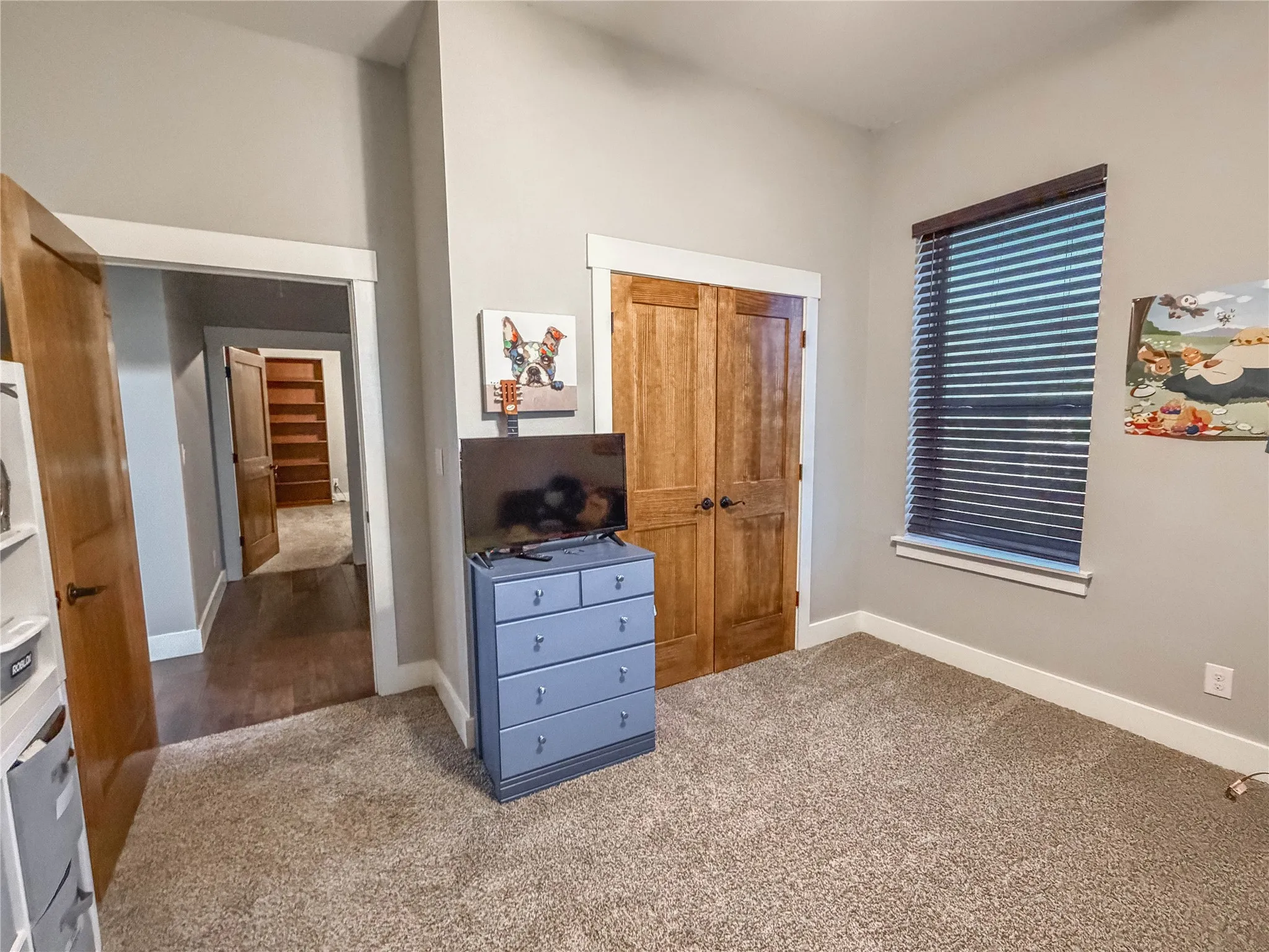Carpeted bedroom with a closet and baseboards