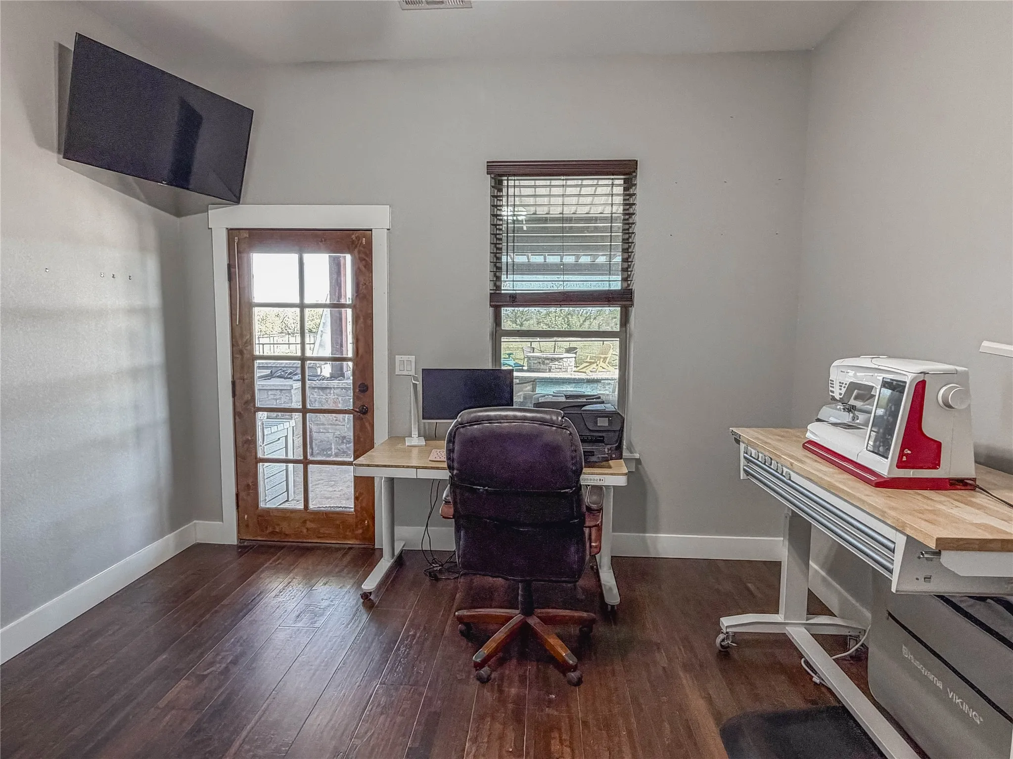 Office featuring dark wood-type flooring and plenty of natural light