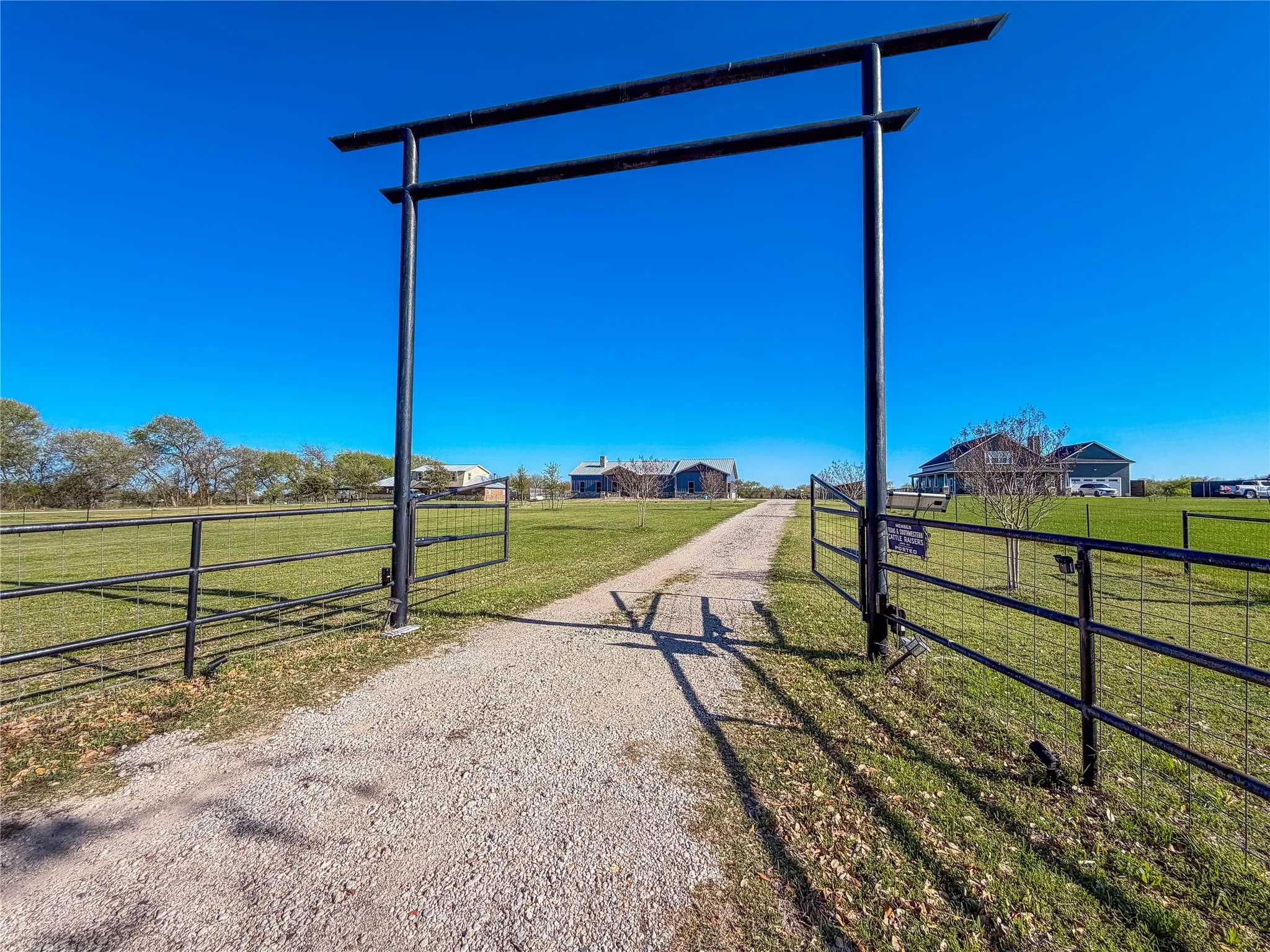 View of dirt / gravel driveway featuring a gated entry, a rural view, and a gate