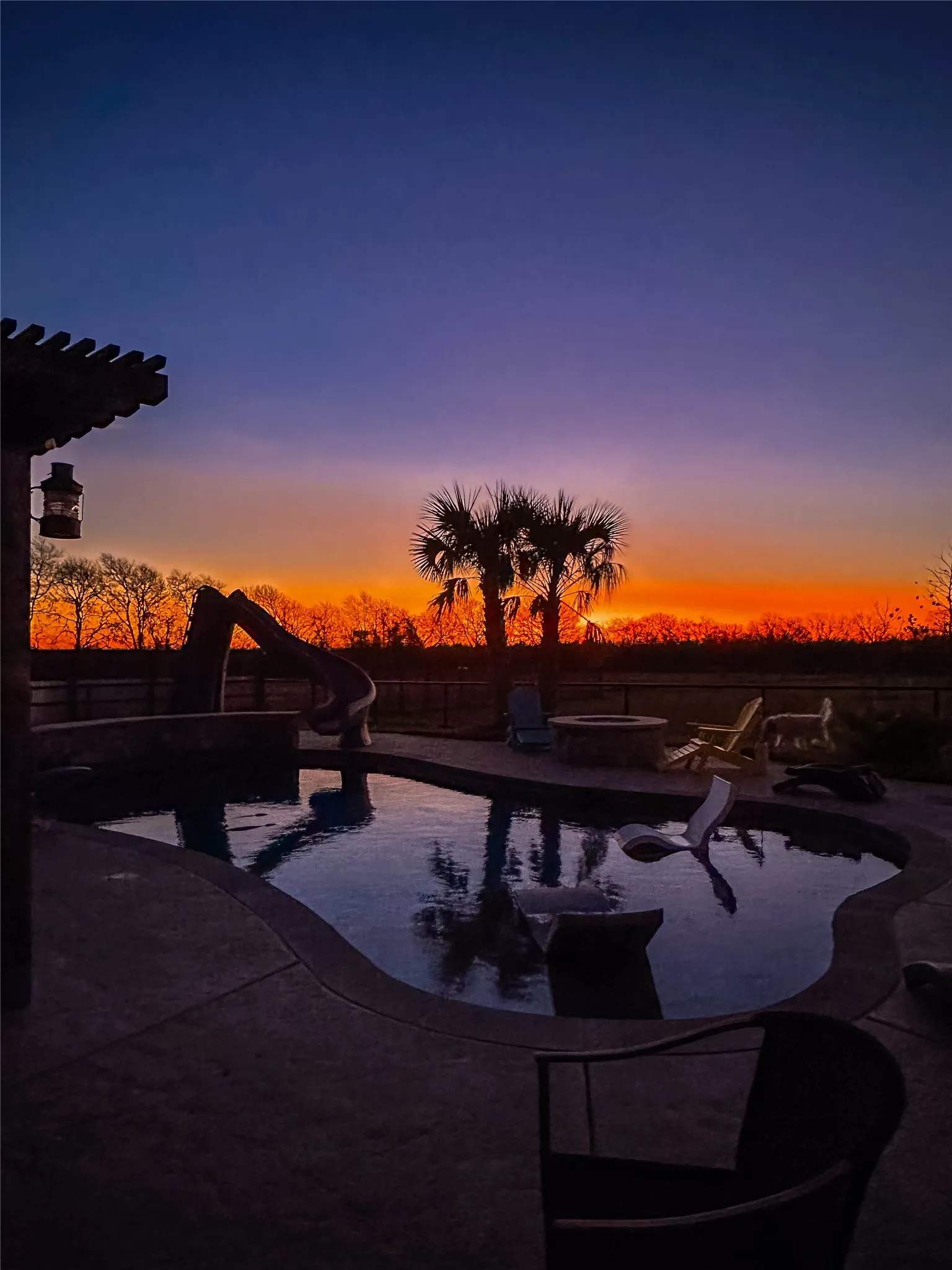 View of swimming pool featuring a water slide, a fenced backyard, patio surround, and a jacuzzi