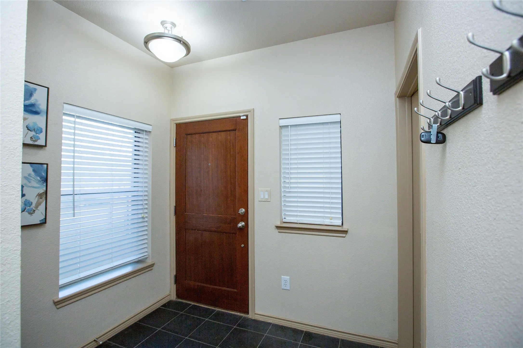 Foyer with dark green tile patterned floors
