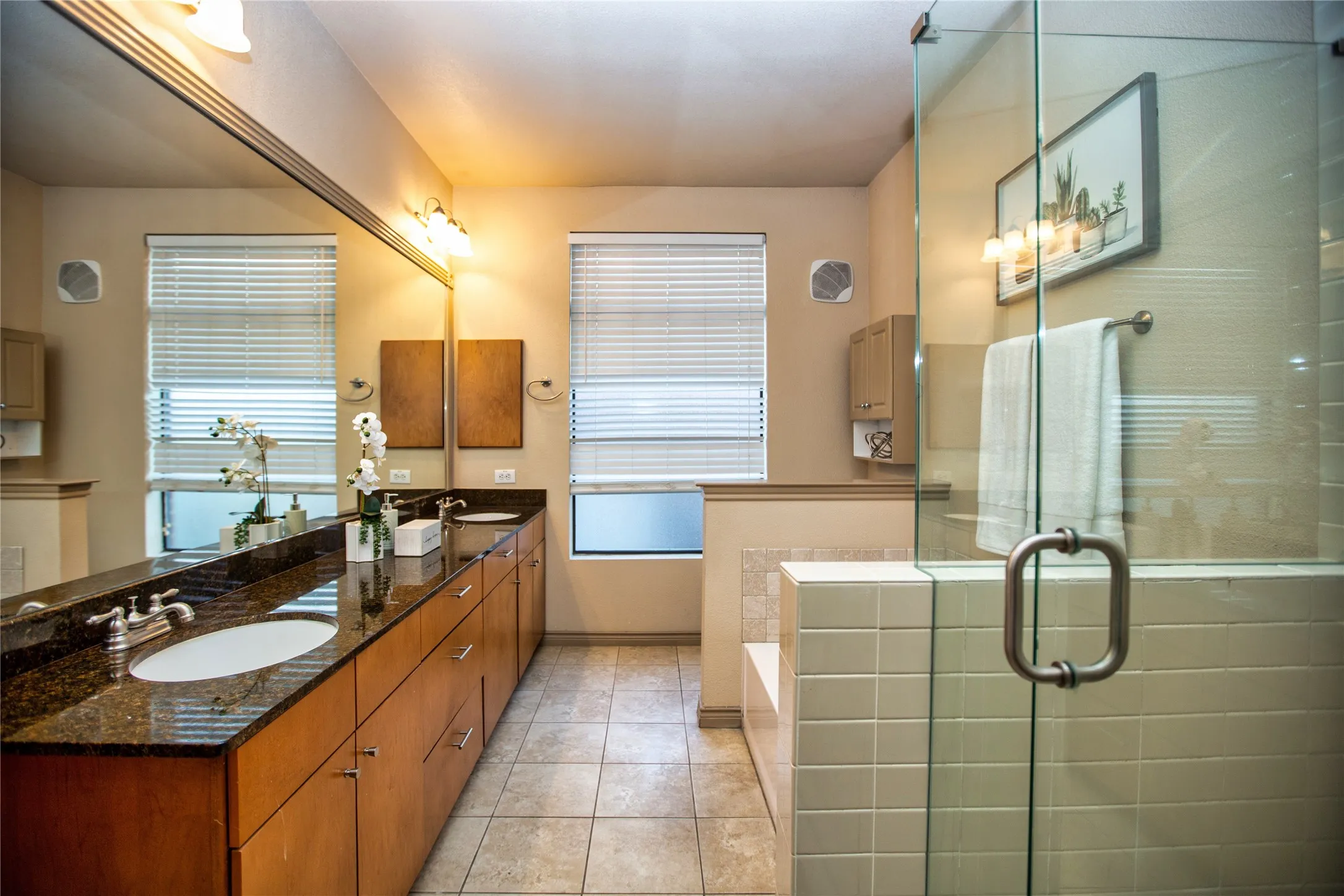 Bathroom featuring double vanity, light tile patterned floors, a stall shower, and a garden tub