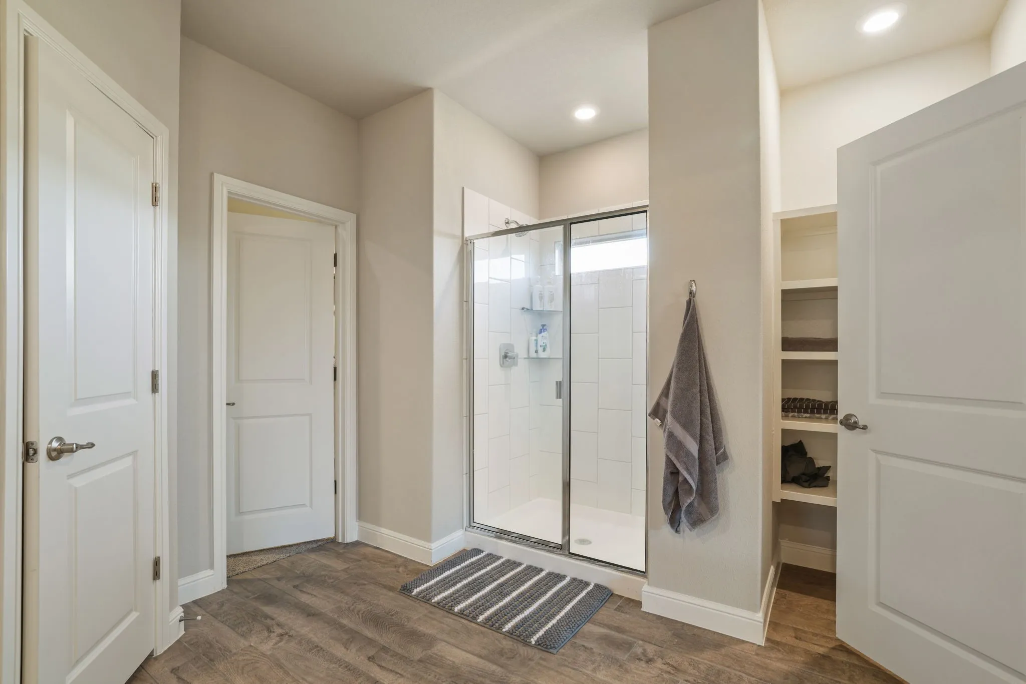 Full bath featuring a stall shower and dark wood-style floors