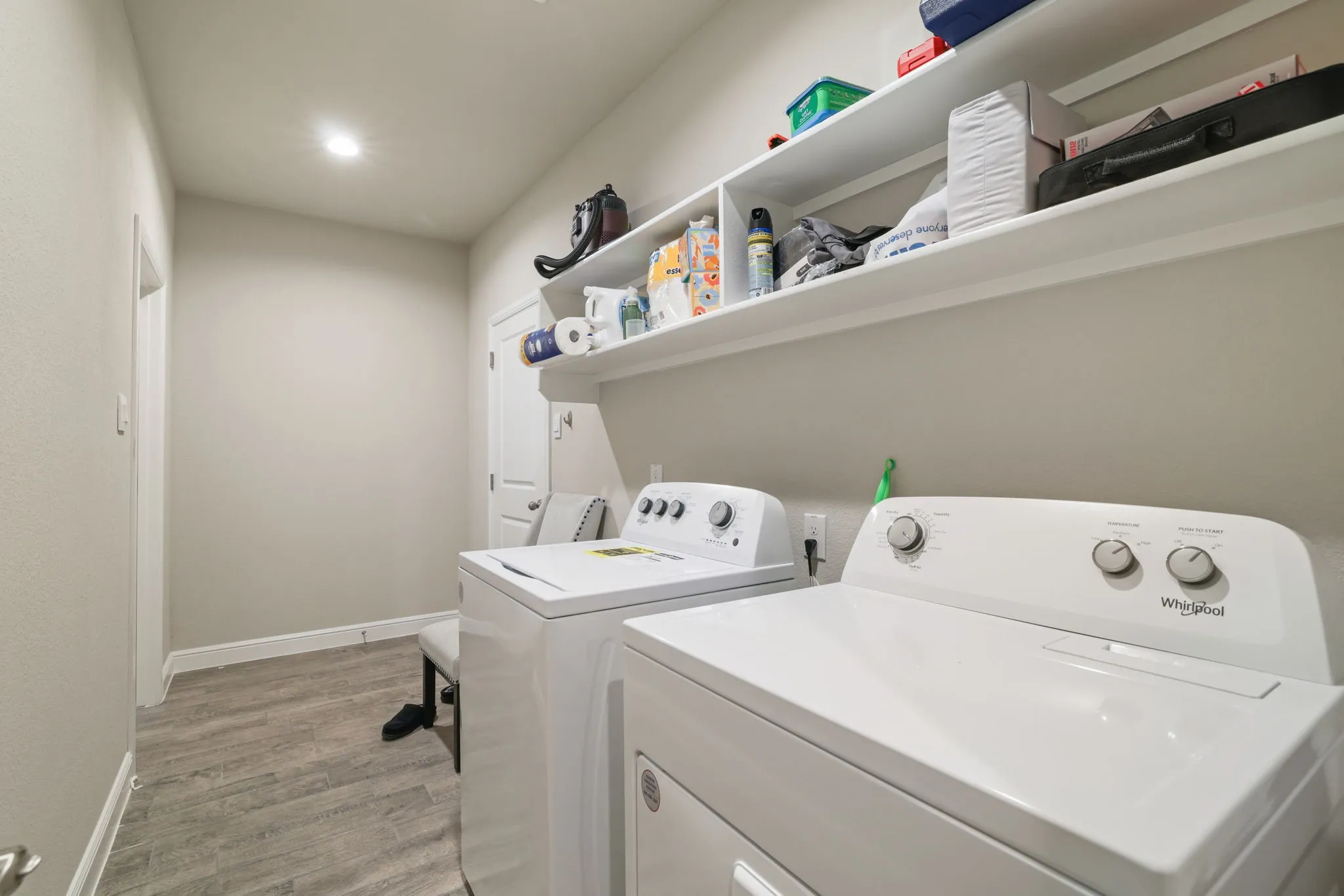 Laundry area featuring light wood-type flooring, separate washer and dryer, and recessed lighting
