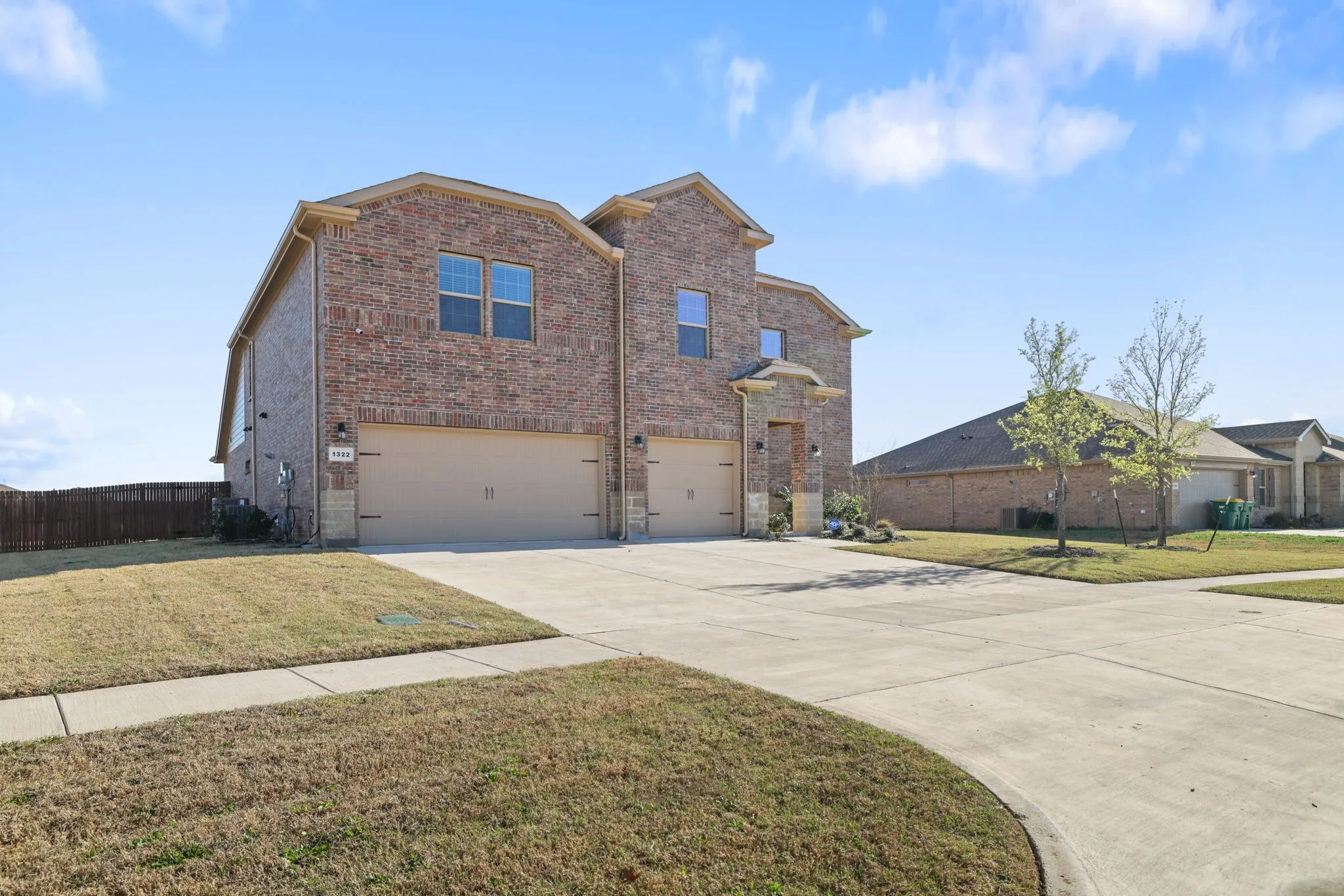 View of front of property with a garage, brick siding, and concrete driveway