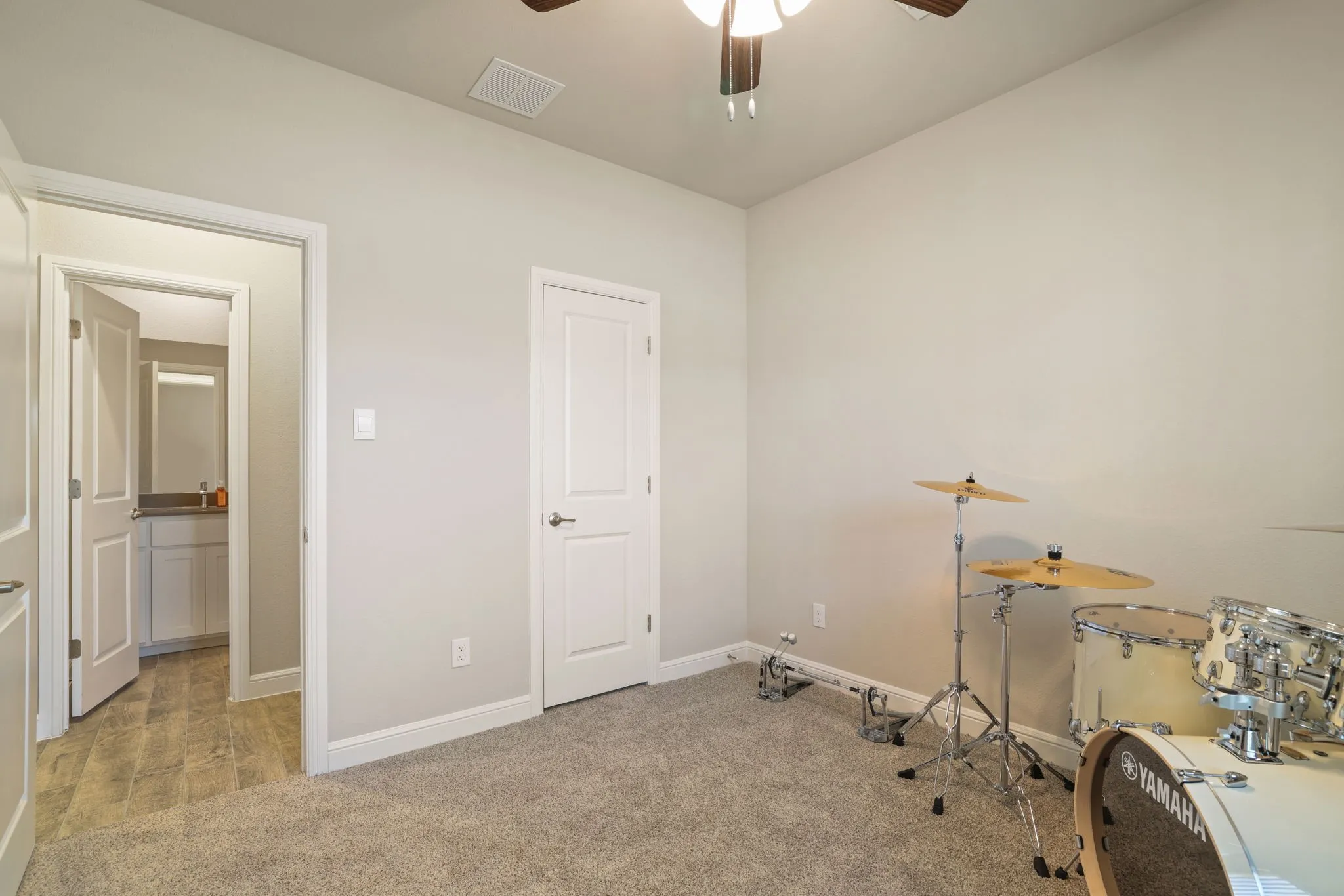 Miscellaneous room with ceiling fan and light carpet