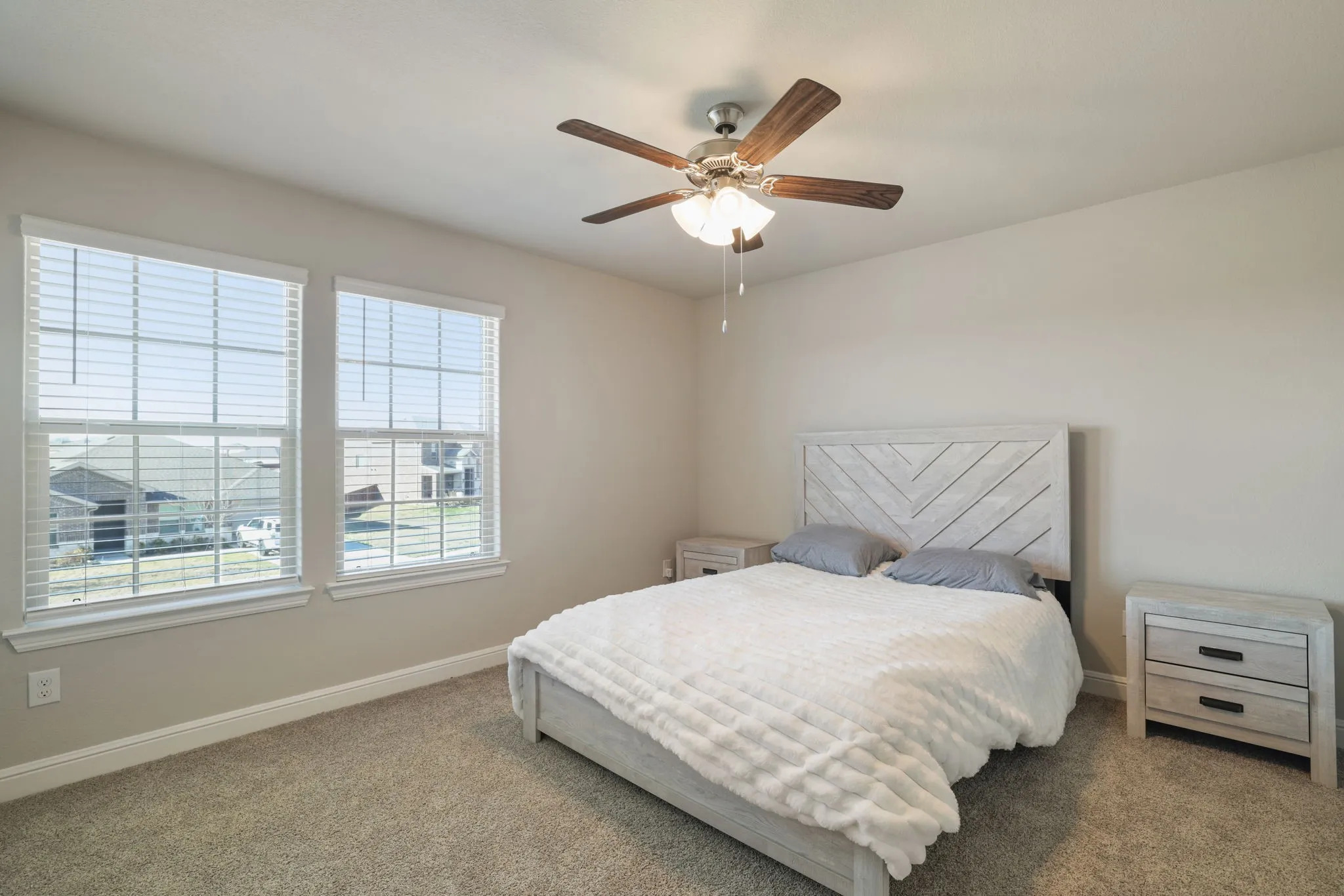 Carpeted bedroom featuring baseboards and ceiling fan