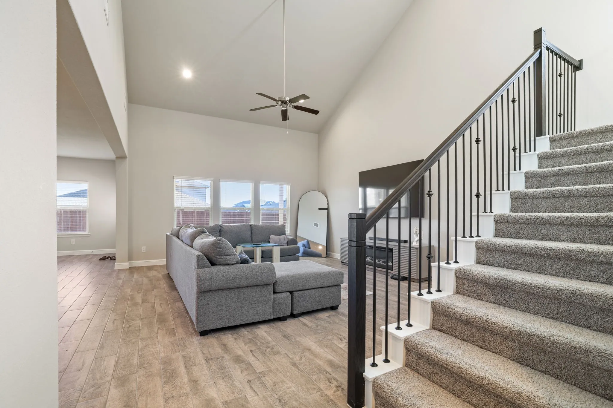 Living area featuring light wood-style floors, lofted ceiling, a ceiling fan, and recessed lighting