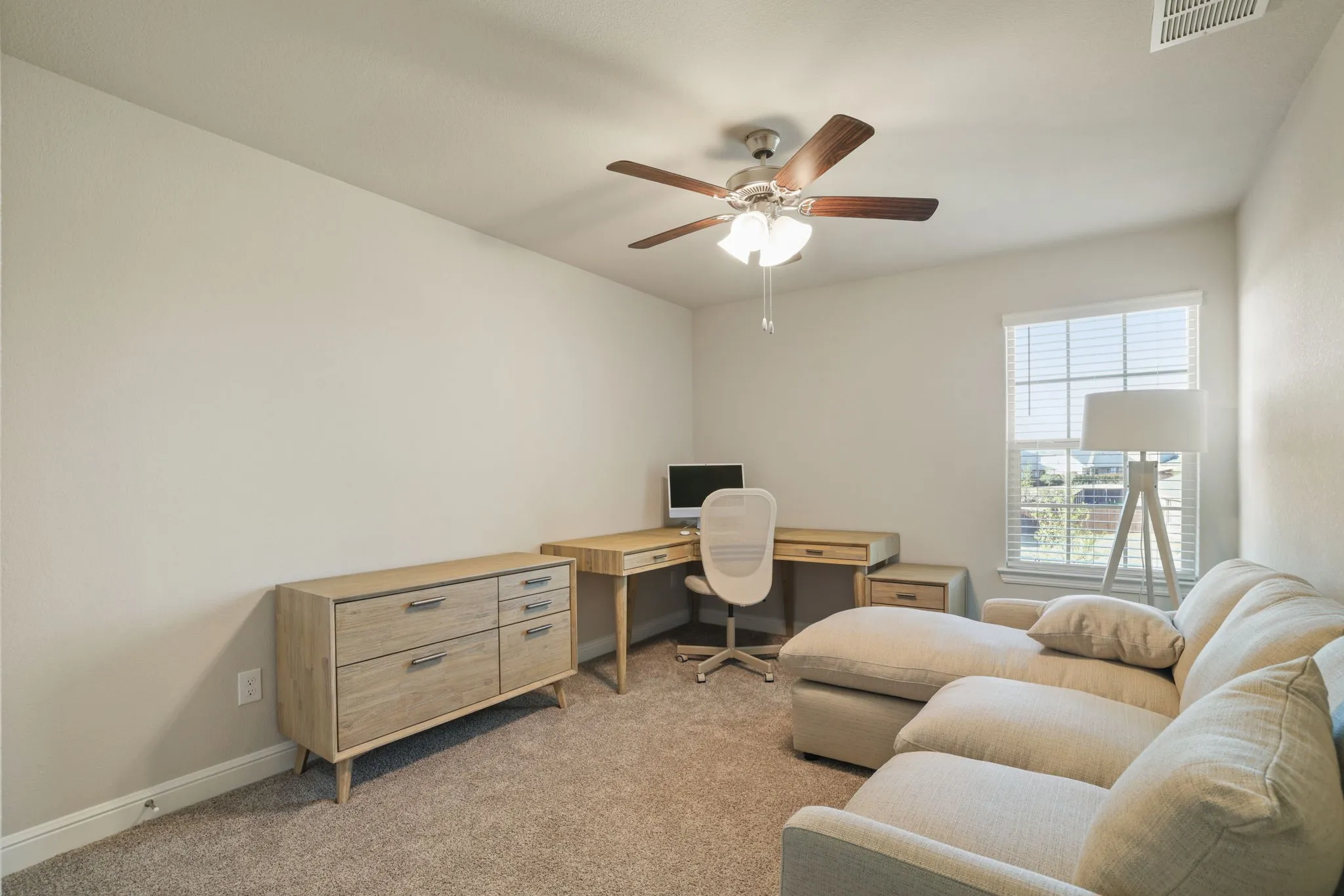 Office space with light carpet and ceiling fan