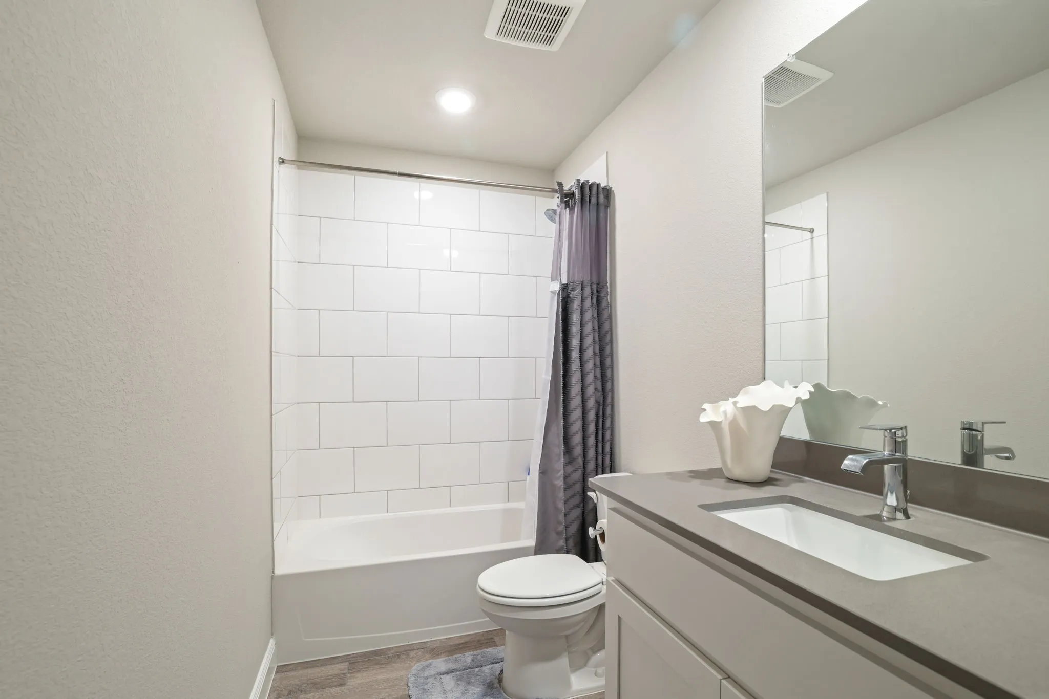 Full bath featuring vanity, light wood-style flooring, and shower / bath combo with shower curtain