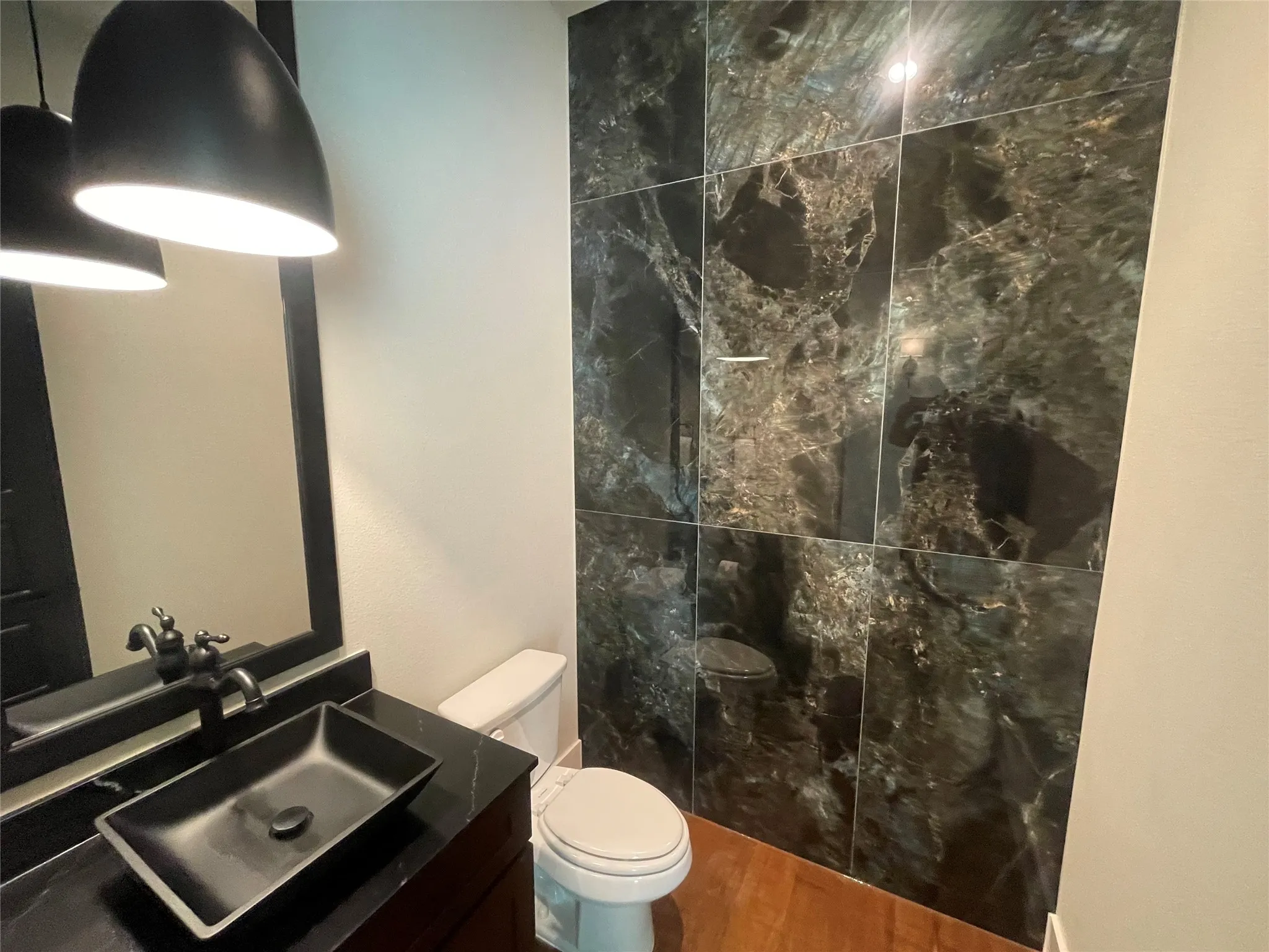 Dark-toned vanity with a rectangular vessel sink and wall-mounted faucet