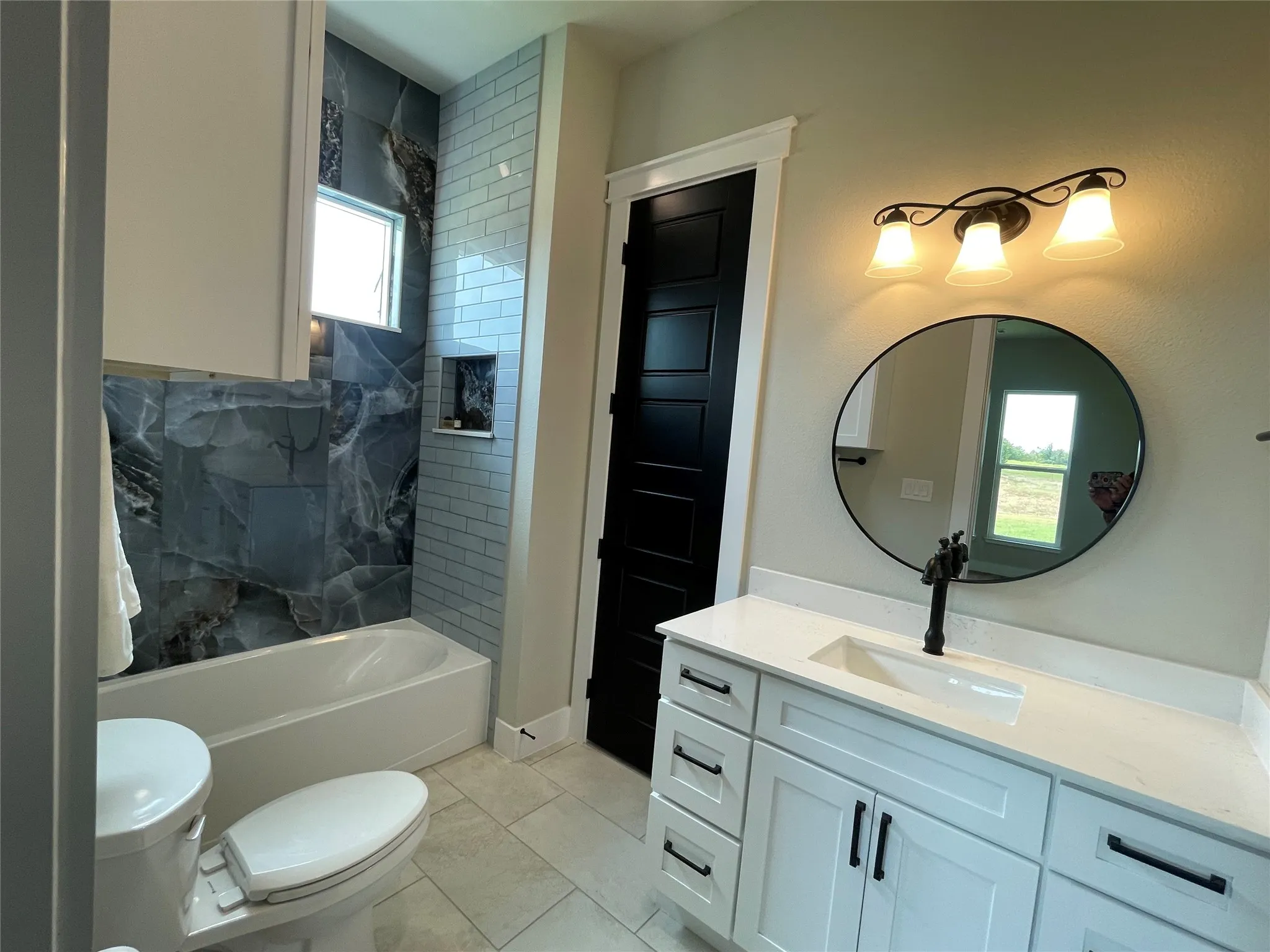 White vanity with integrated sink and dark hardware