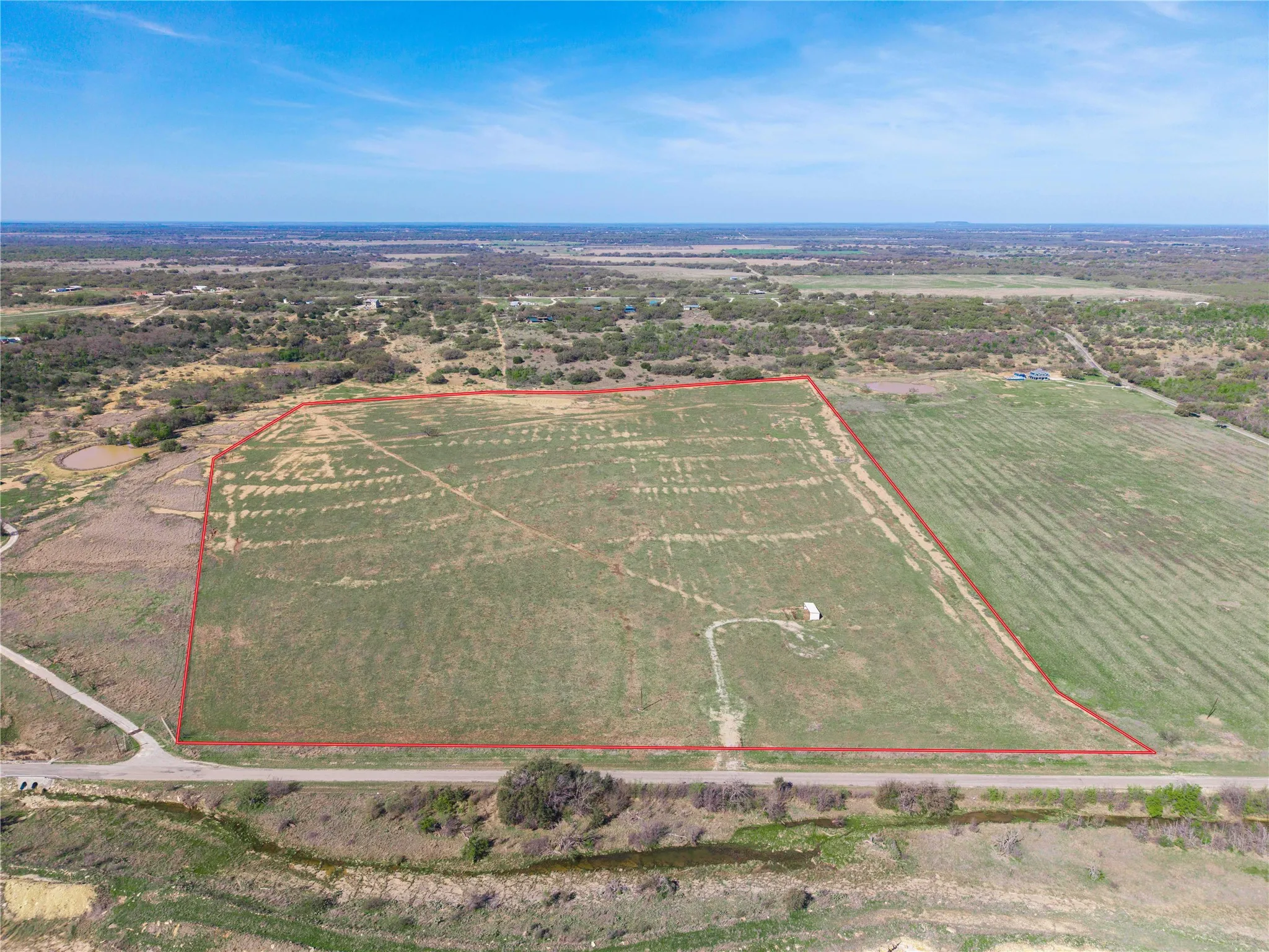Aerial view of sparsely populated area with property boundaries highlighted and rows of crops