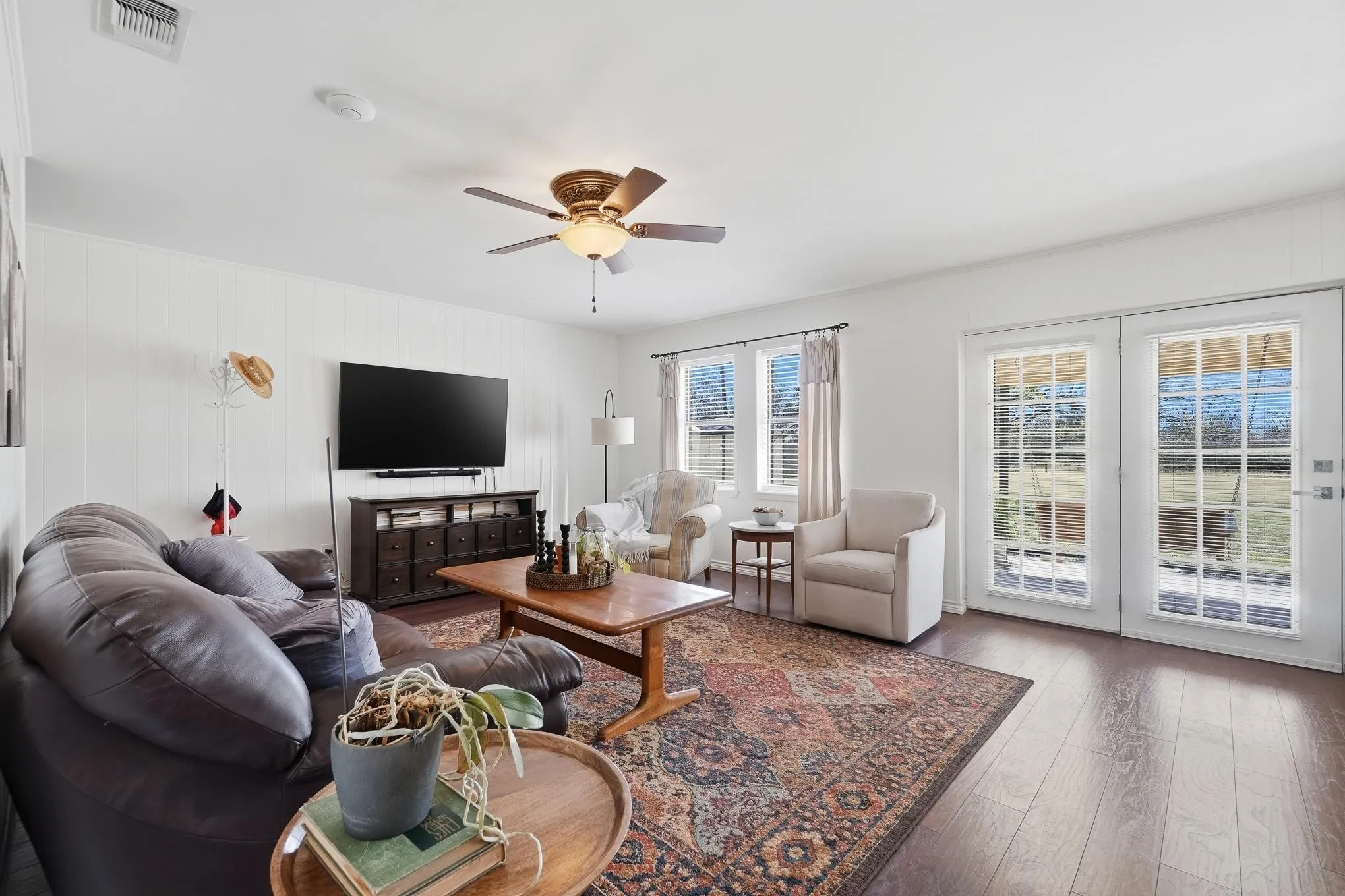 Living area with hardwood / wood-style flooring and a ceiling fan