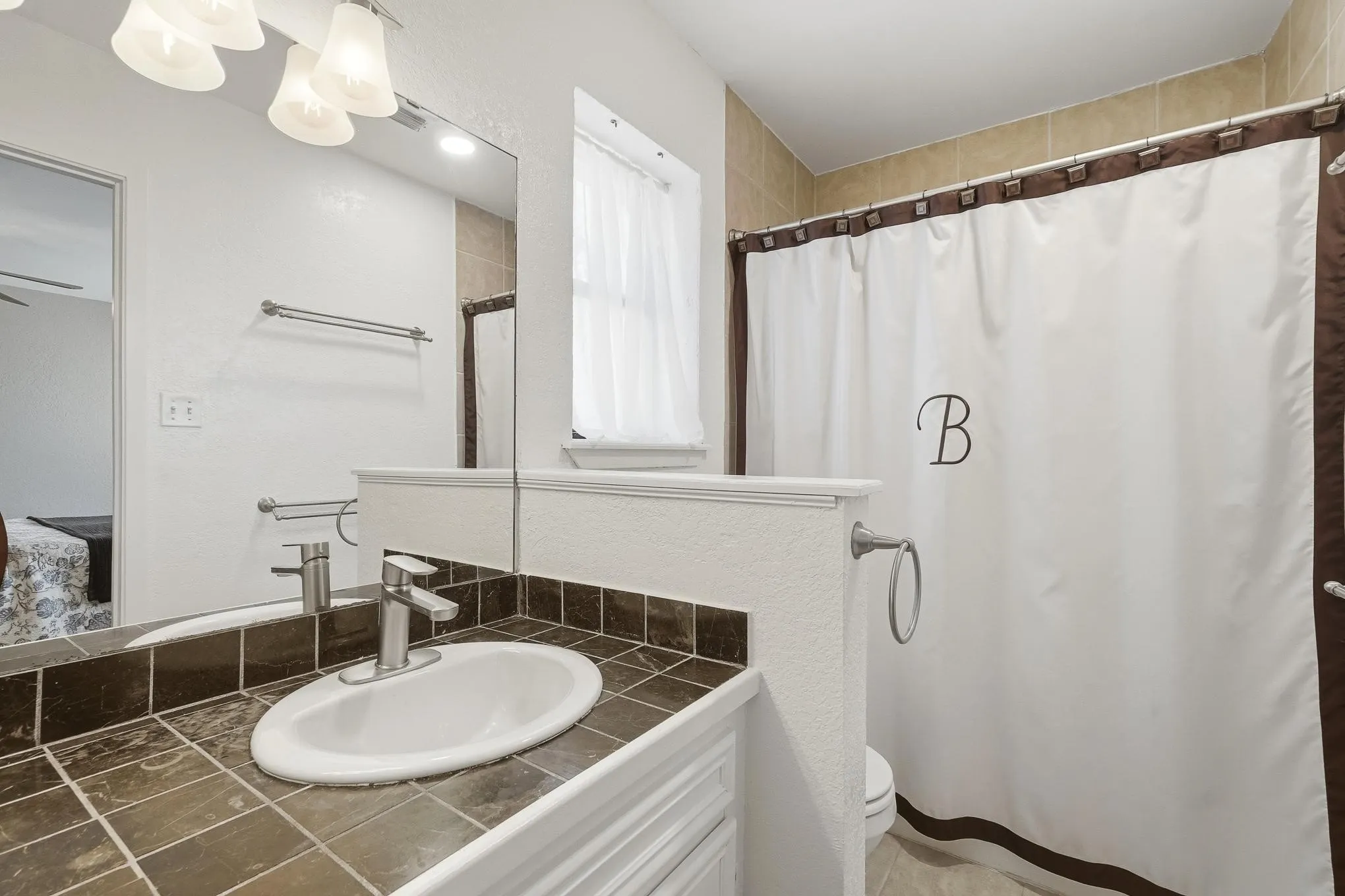 Ensuite bathroom featuring vanity and a shower with shower curtain