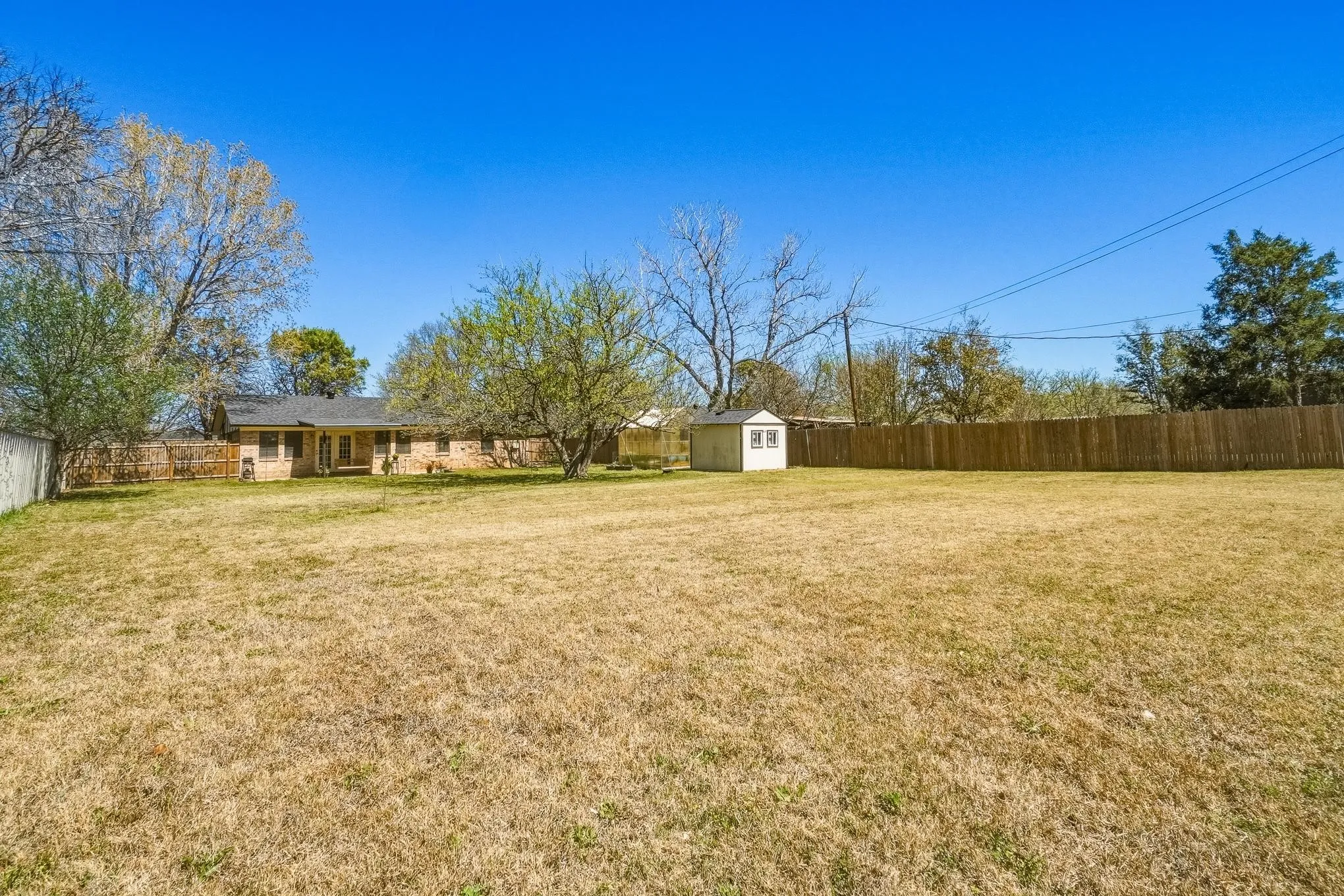 Fenced backyard with a storage unit