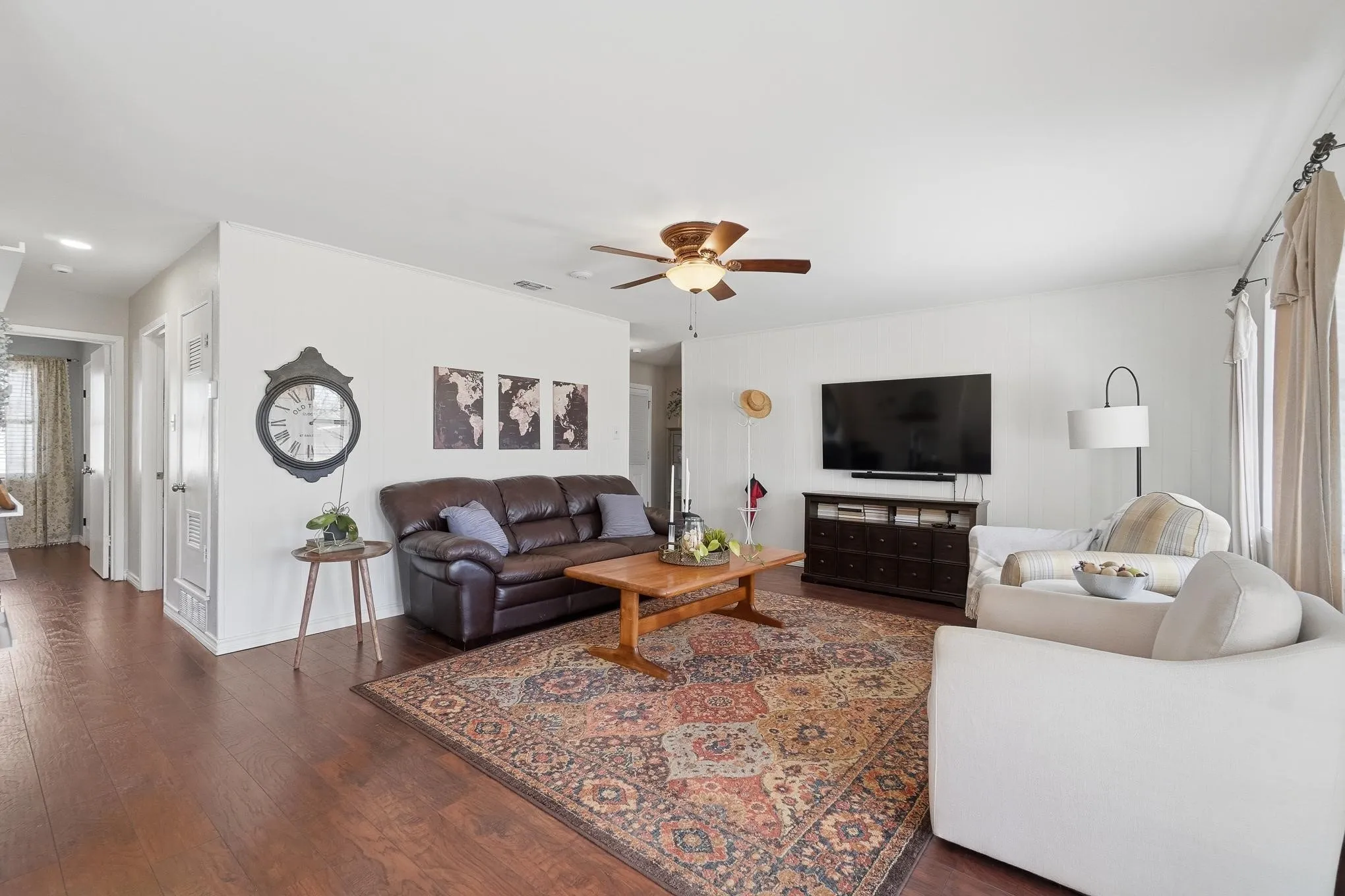 Living area with plenty of natural light, wood-type flooring, and a ceiling fan