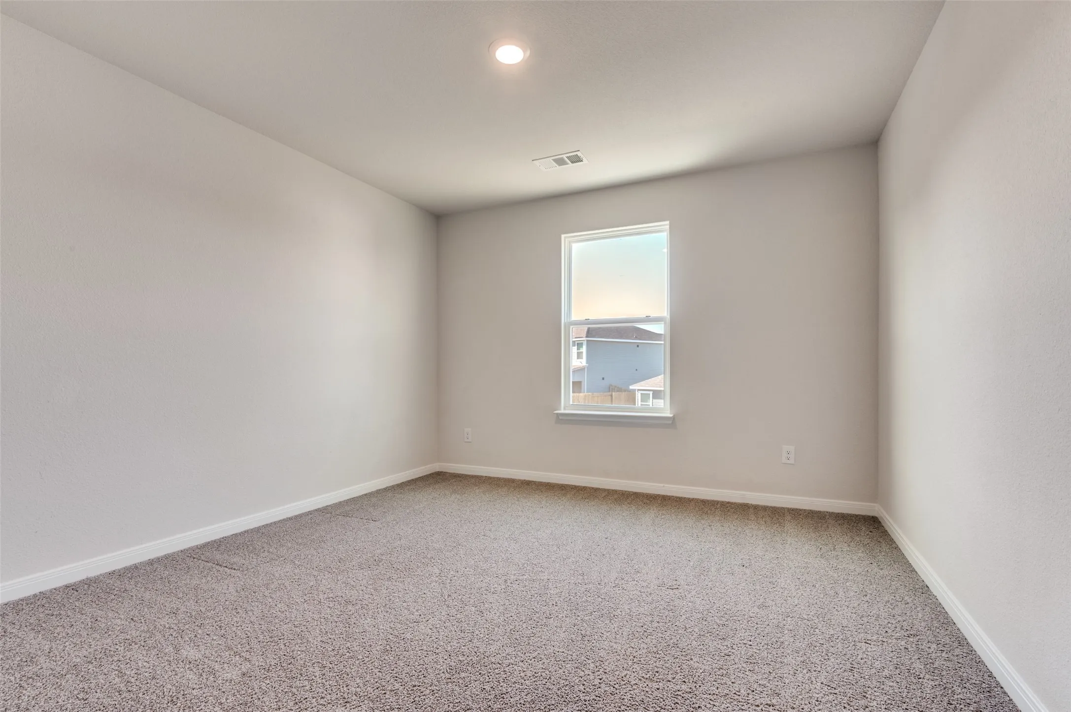 Empty room featuring light carpet and baseboards