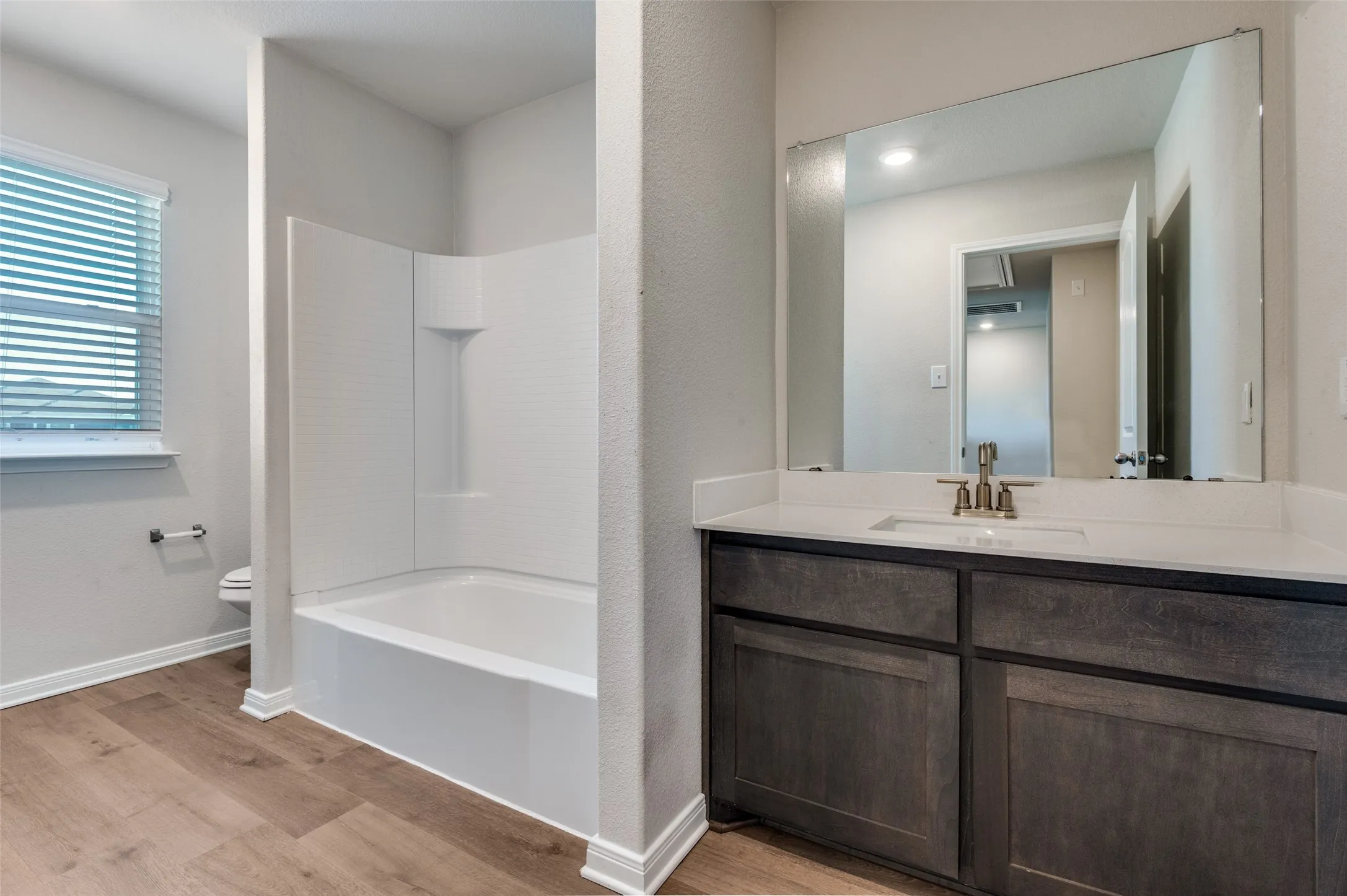 Bathroom featuring vanity, light wood-style flooring, and shower / bath combination