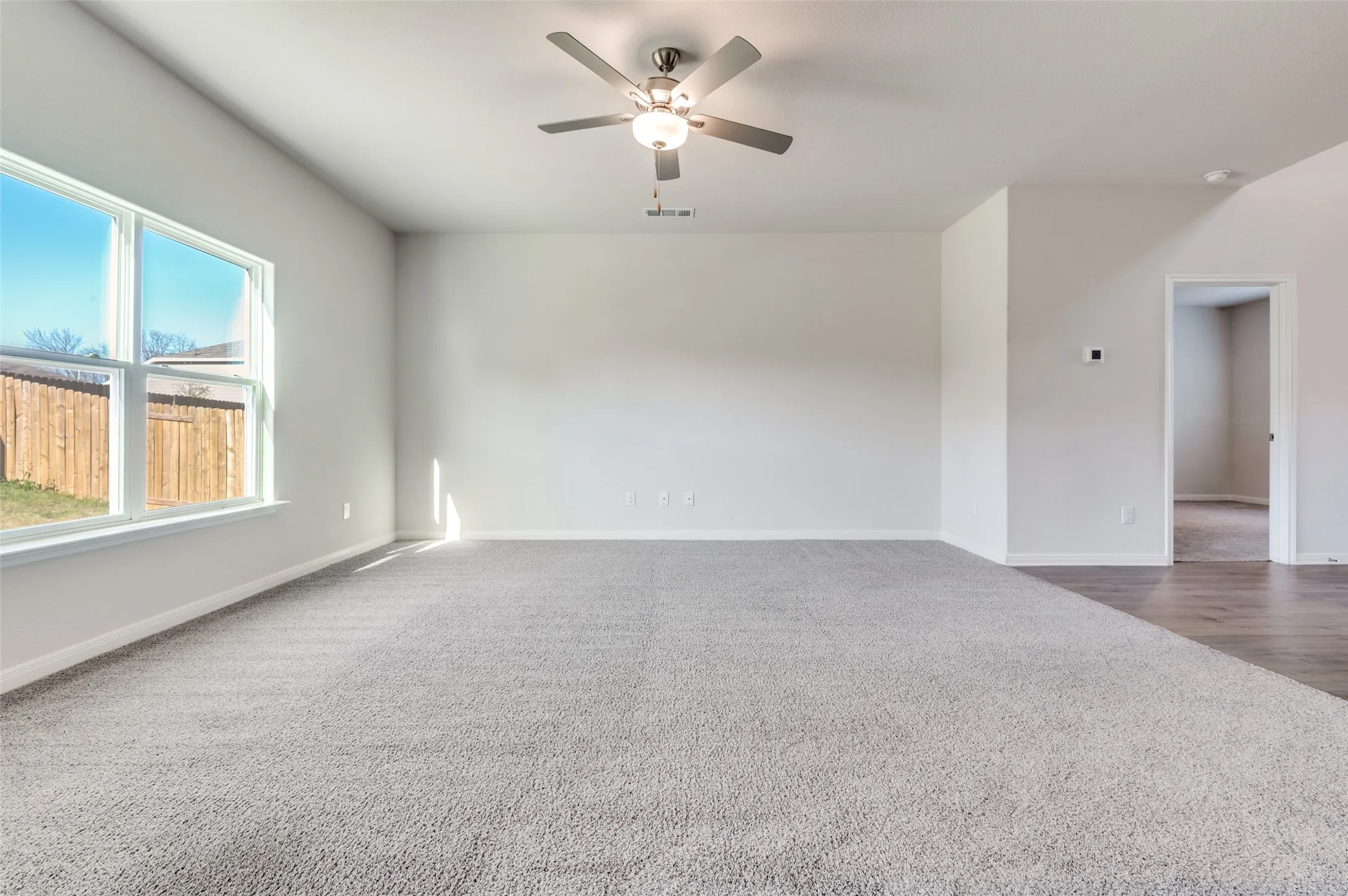 Spare room featuring a ceiling fan and dark carpet