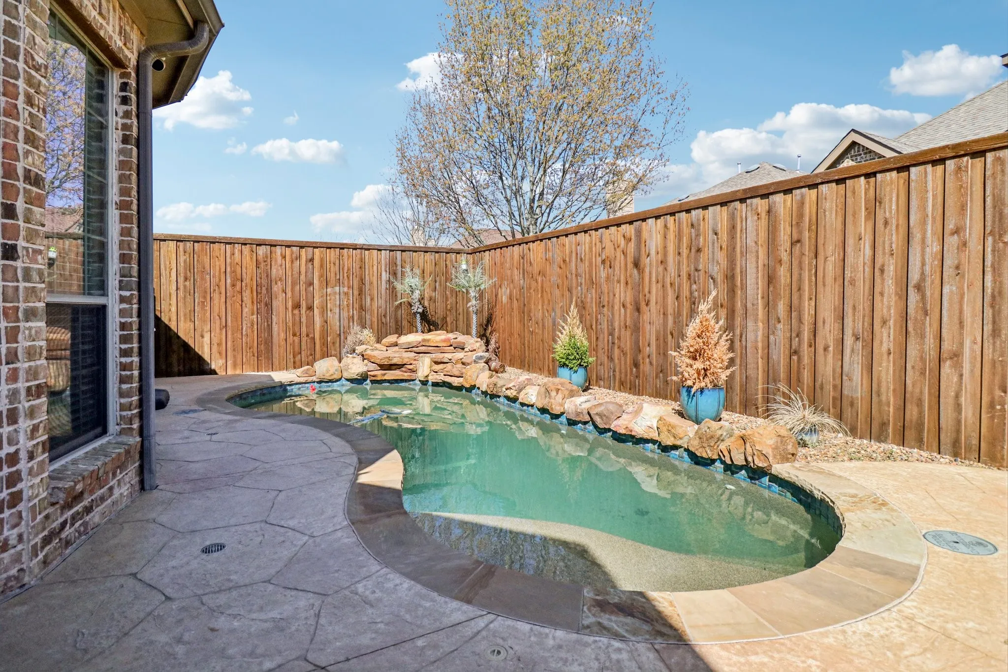 View of pool featuring a fenced backyard and patio surround