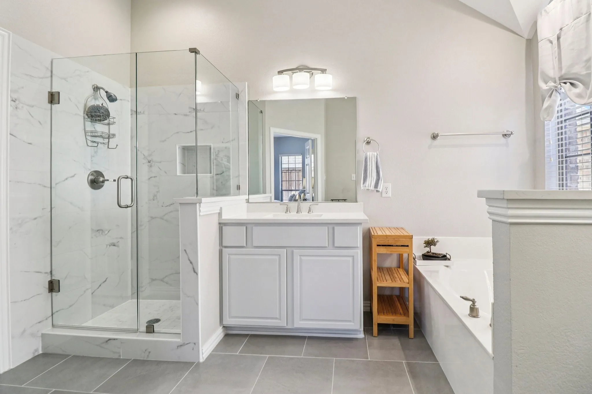 Bathroom featuring vanity, a bath, a marble finish shower, and light tile patterned floors
