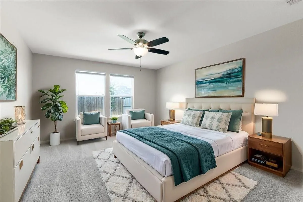 Bedroom featuring light gray carpeting, two large windows, a ceiling fan with integrated lighting, and a tufted headboard