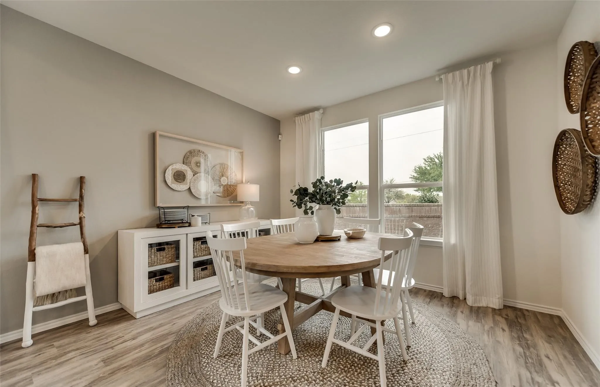 Dining area featuring wood-finish flooring, recessed lighting, and large windows with white trim