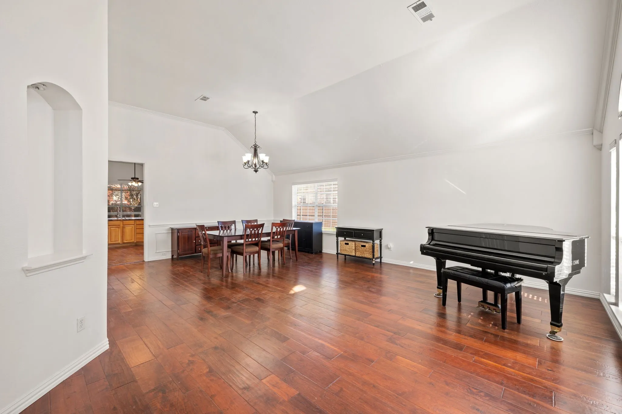 Dining area with dark wood-style flooring, lofted ceiling, and a chandelier